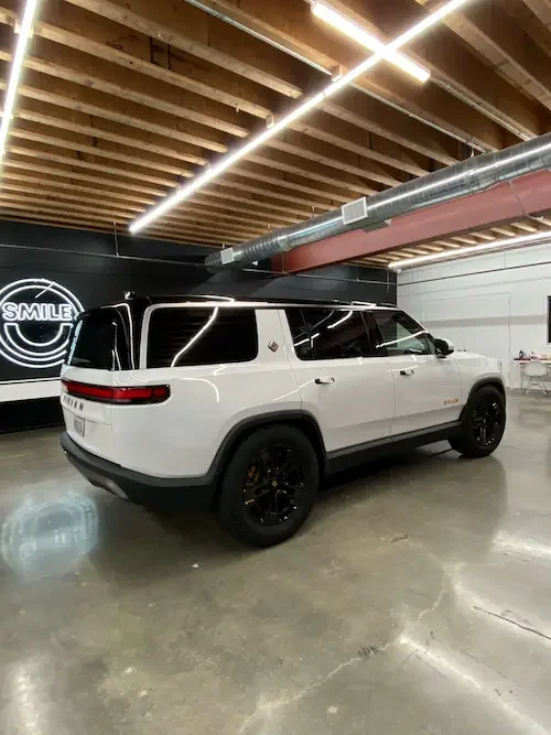 White Rivian SUV with black wheels