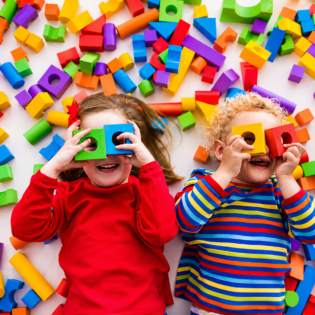 Young children playing with colorful building blocks during a creative learning activity at a daycare and early childhood education center.