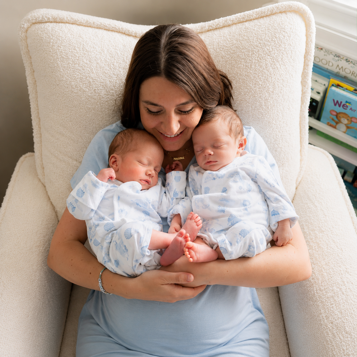 Newborn care specialist gently caring for sleeping twin babies in a comfortable home environment, providing professional infant care and support.
