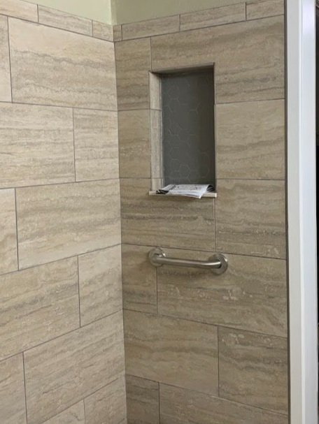 Tile & Niche: Installed client-selected porcelain wall panels, featuring an inset niche at reach