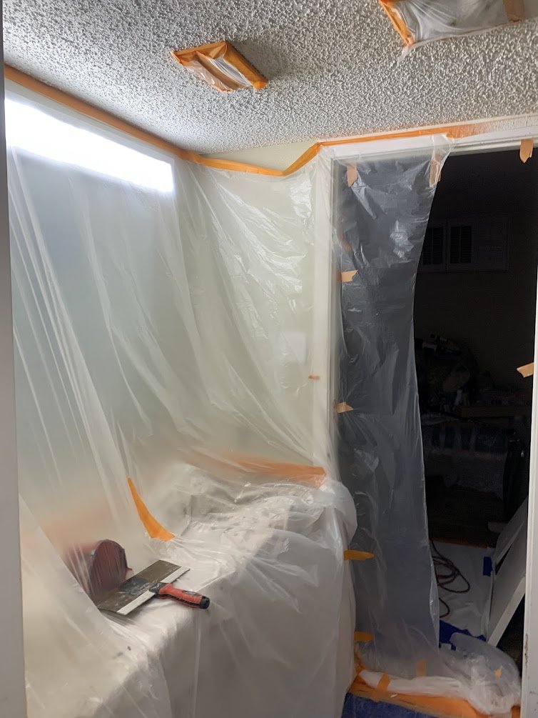 Condo Dust Containment:
Protecting the living area in a downtown unit with taped plastic sheeting.