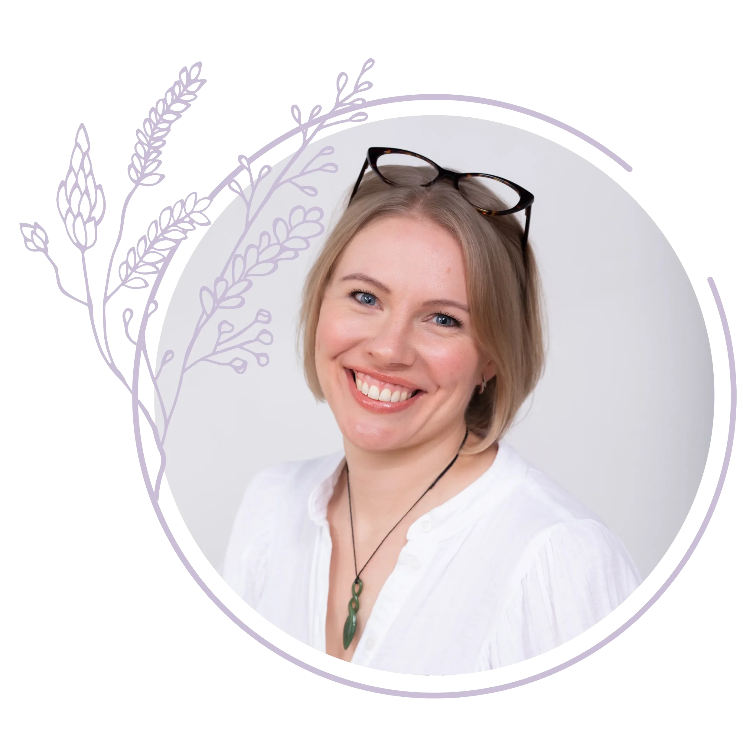 A woman with short blonde hair smiling, wearing glasses on her head, a white shirt, and a greenstone pendant necklace, against a white background.