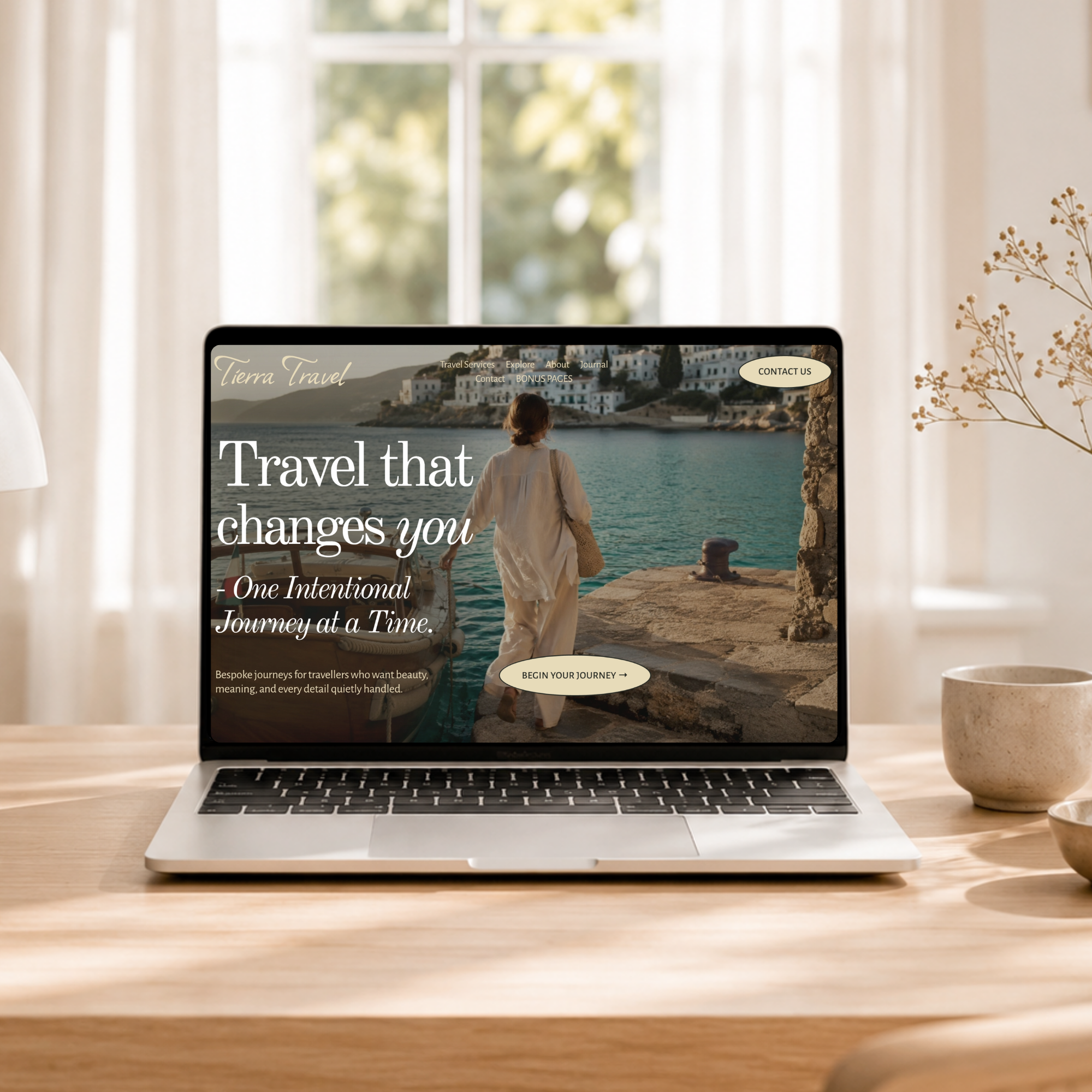 Laptop displaying a Tierra Travel website featuring a seaside village, traveler, and bespoke travel services, designed by Volar Creative Studio.