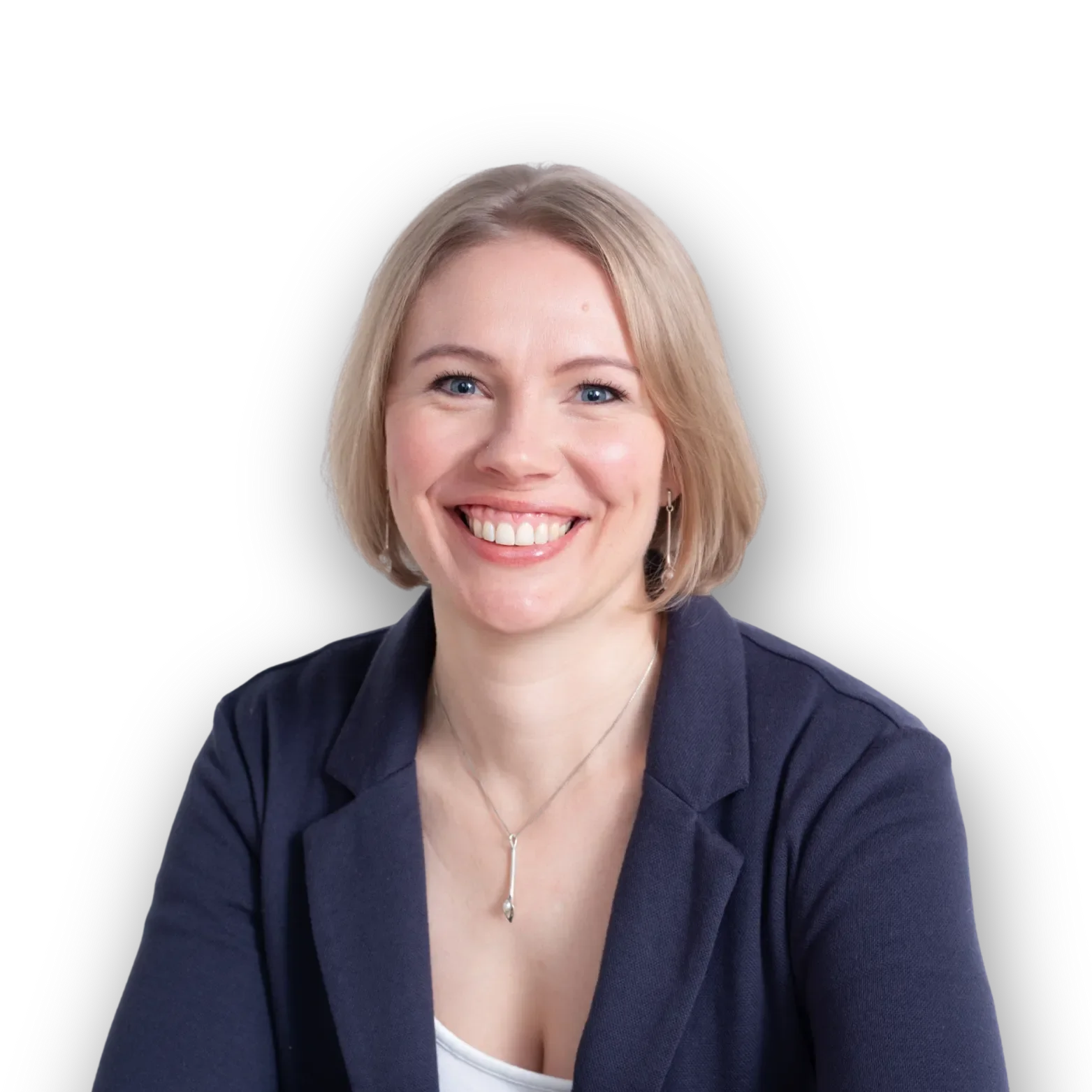 Headshot of a smiling woman with blonde hair, blue eyes, wearing a navy blazer, a white top, earrings, and a necklace, against a black background.