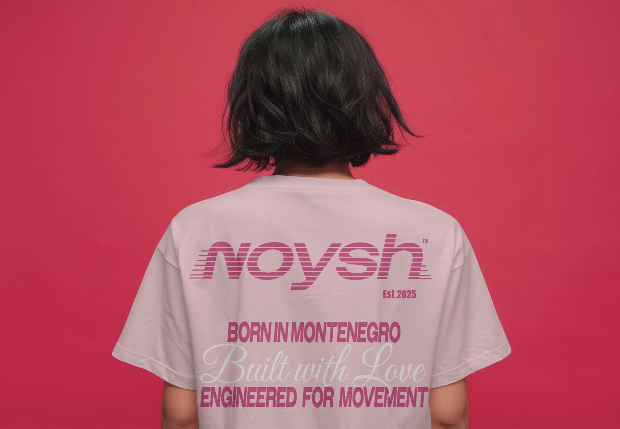 Back of a person wearing a white T-shirt with pink text and a pink background