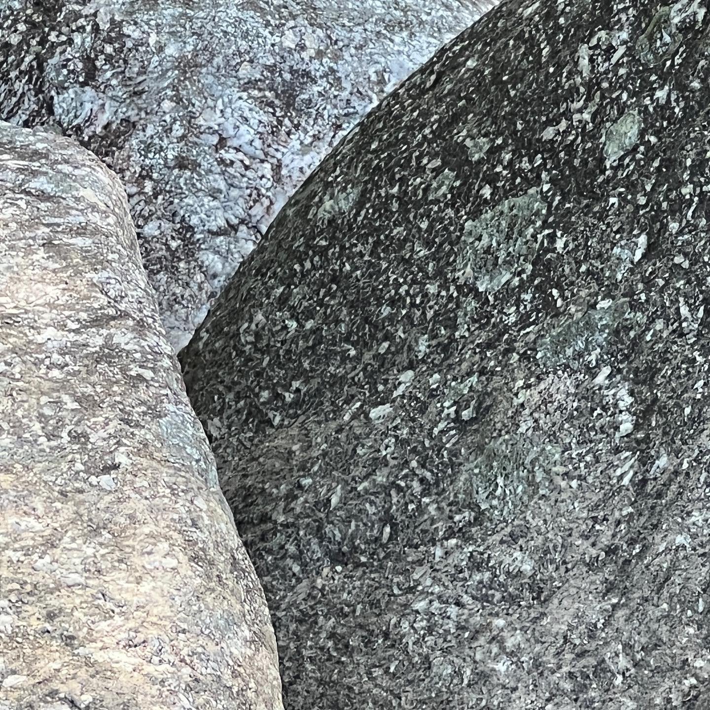 Close-up of two large rocks with rough, textured surfaces, one lighter and one darker.
