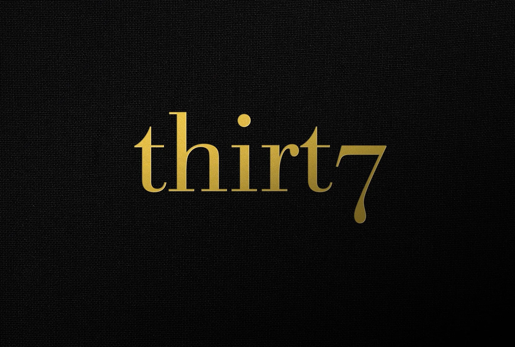 The word 'thirty' written in gold on a black textured background.