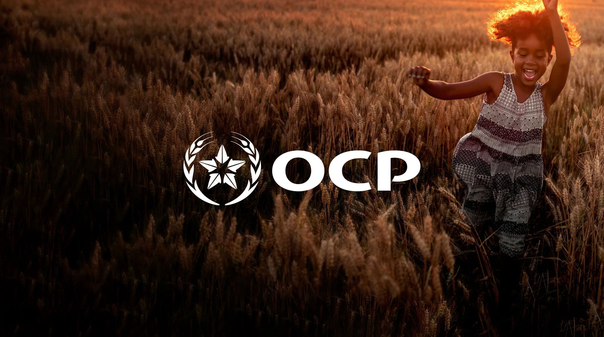 A young girl running and playing in a wheat field during sunset, with the OCP logo overlaid.