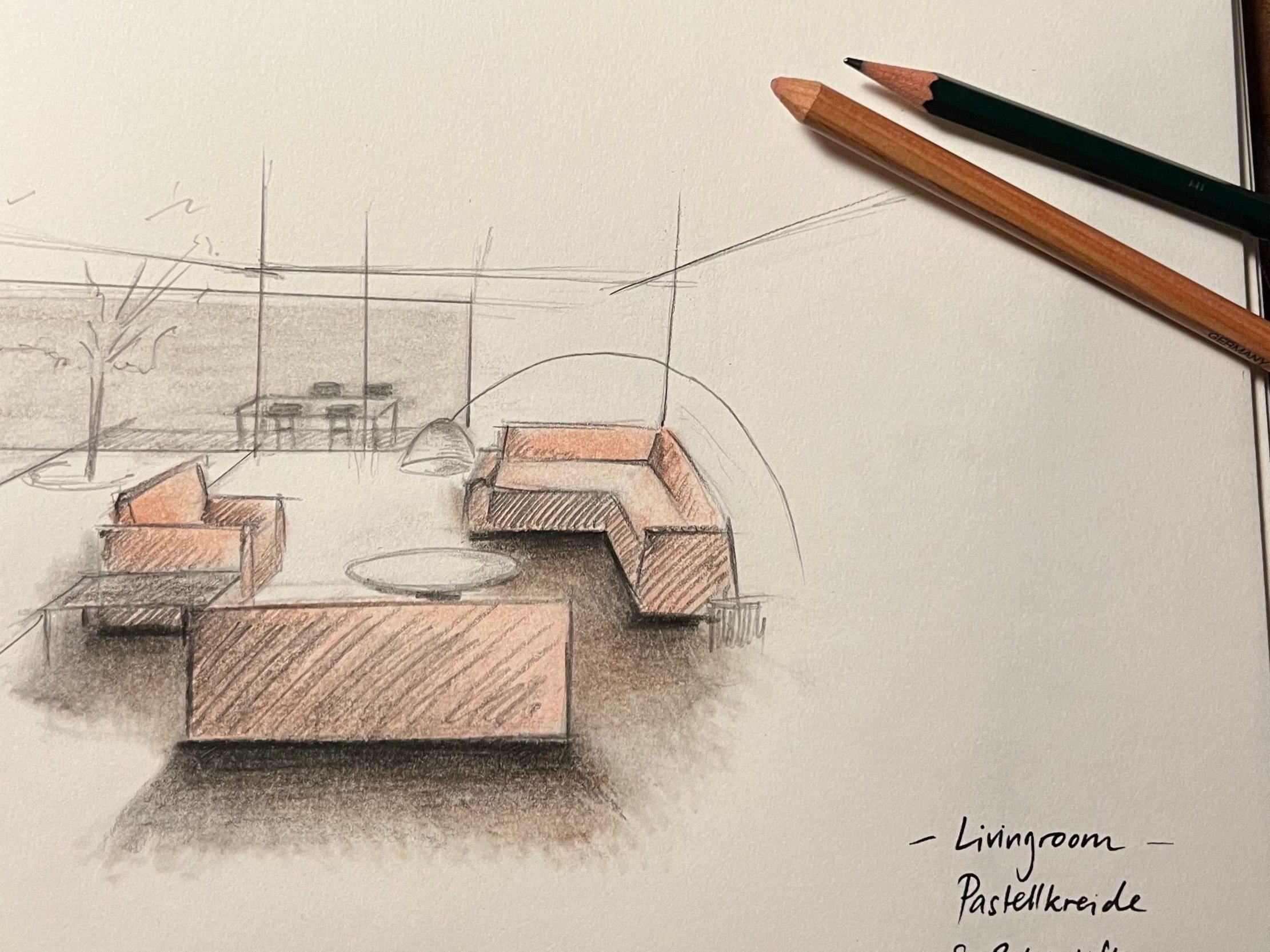 Skizze eines Wohnzimmers mit Sofa, Sesseln, Couchtisch und Blick nach draußen durch große Fenster, mit Bleistift und Farbstiften. Handgeschriebenes Text: Livingroom Pastellkreide.