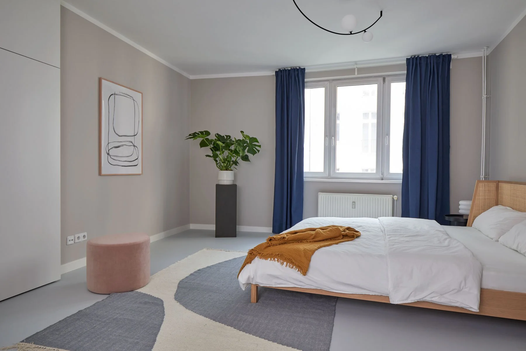 Contemporary bedroom with wooden bed frame, blue curtains and minimalist decor, apartment in Berlin Mitte, interior design, Innenausbau, Ausstattung and styling by Steffi Bühlmaier, photography by Tobias Bärmann, 2024
