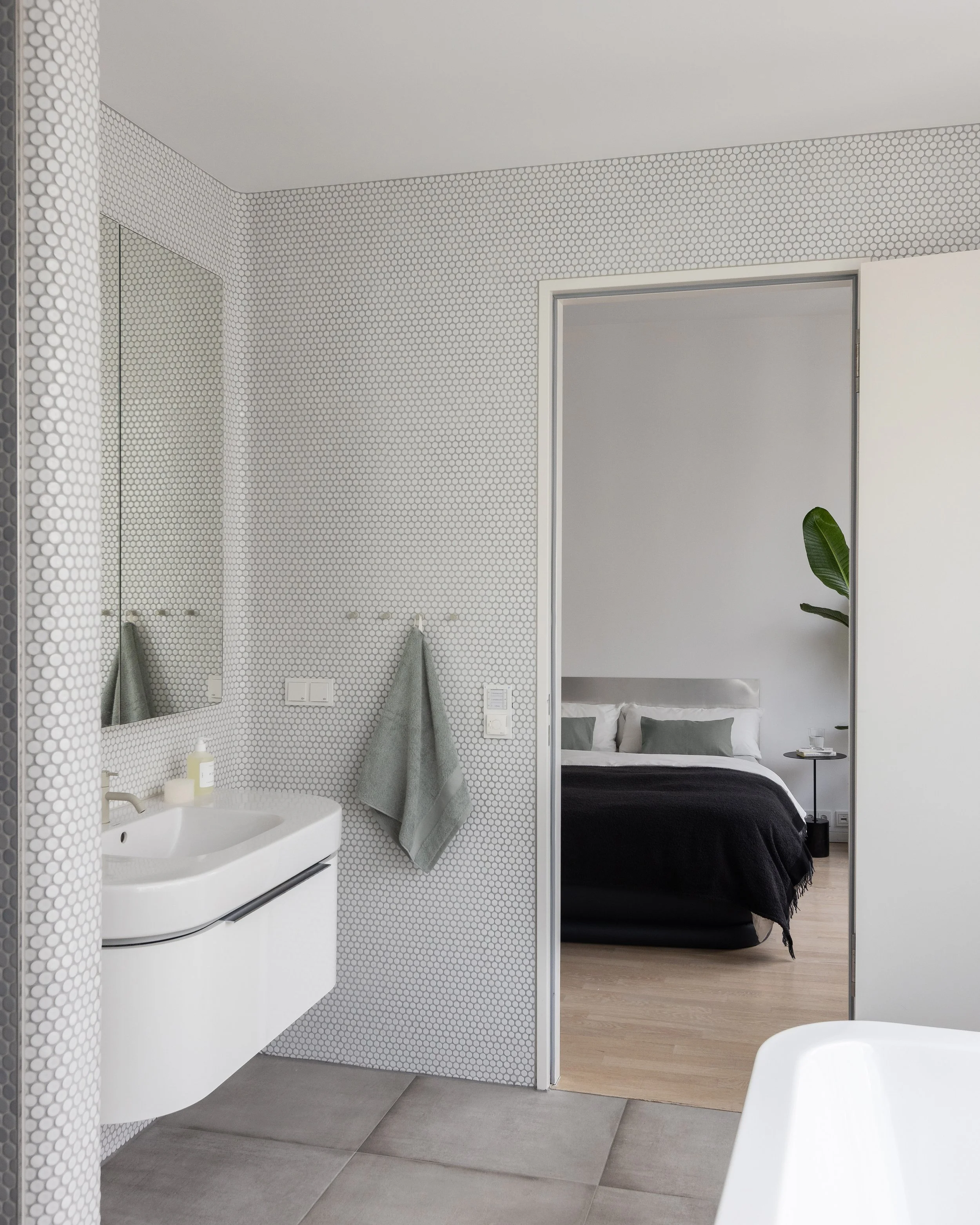 Minimal bathroom with mosaic tiles and view into bedroom, apartment in Berlin Mitte, home staging and interior styling by Steffi Bühlmaier, photography by Jordana Schramm, 2025