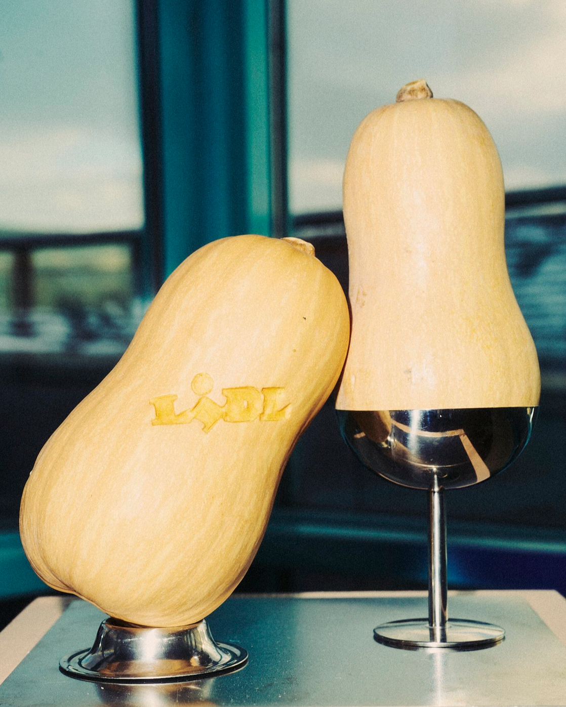 Butternut squash displayed on chrome stands with carved Lidl logo, event design and props styling by Steffi Bühlmaier for Lidl x Highsnobiety dinner at Ember Rooftop Berlin, production by PS:KAAS, 2025