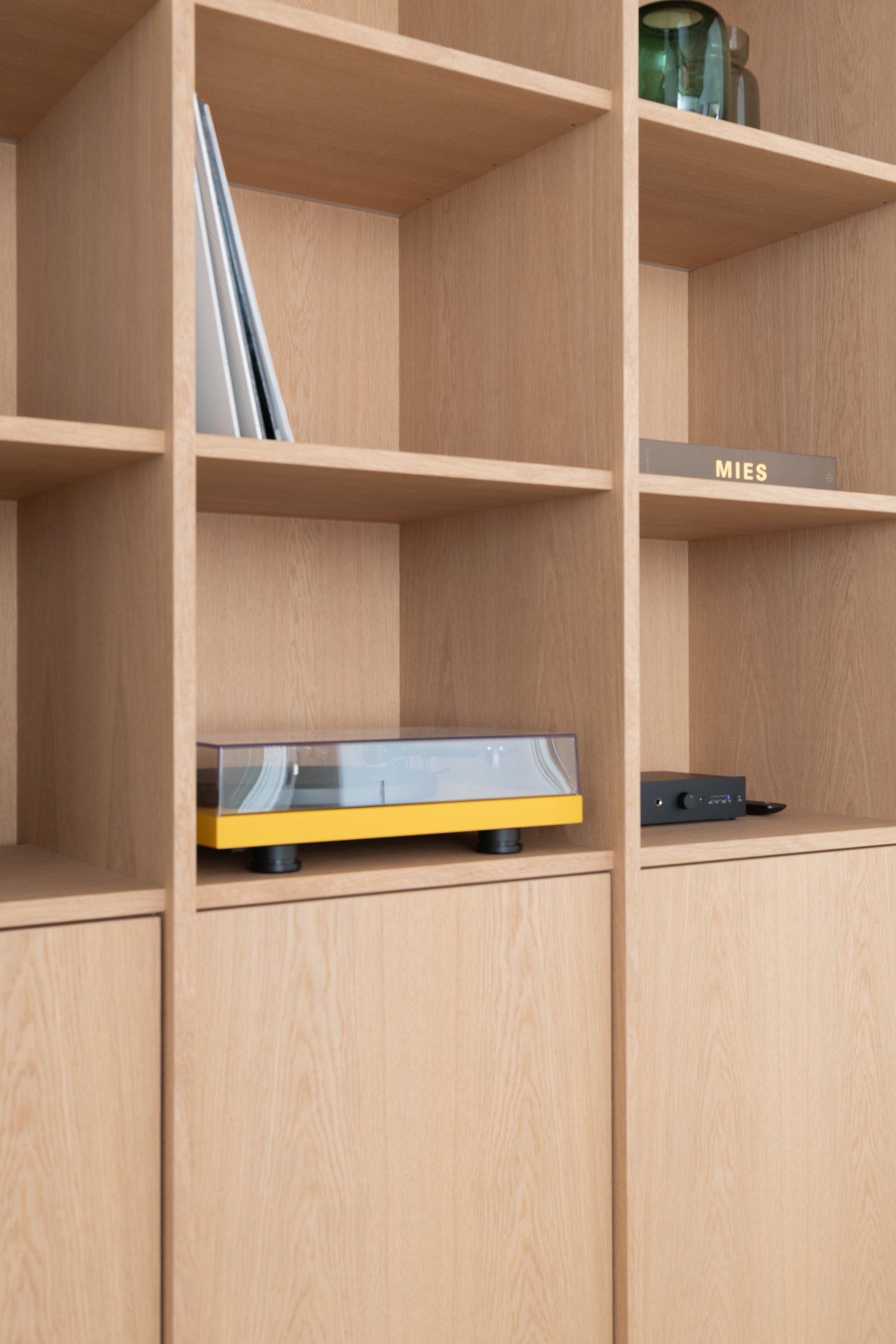 Built-in oak shelving detail with turntable and design books, office interior in Berlin Charlottenburg, Ausstattung and interior styling by Steffi Bühlmaier, architecture by BBPA, 2024