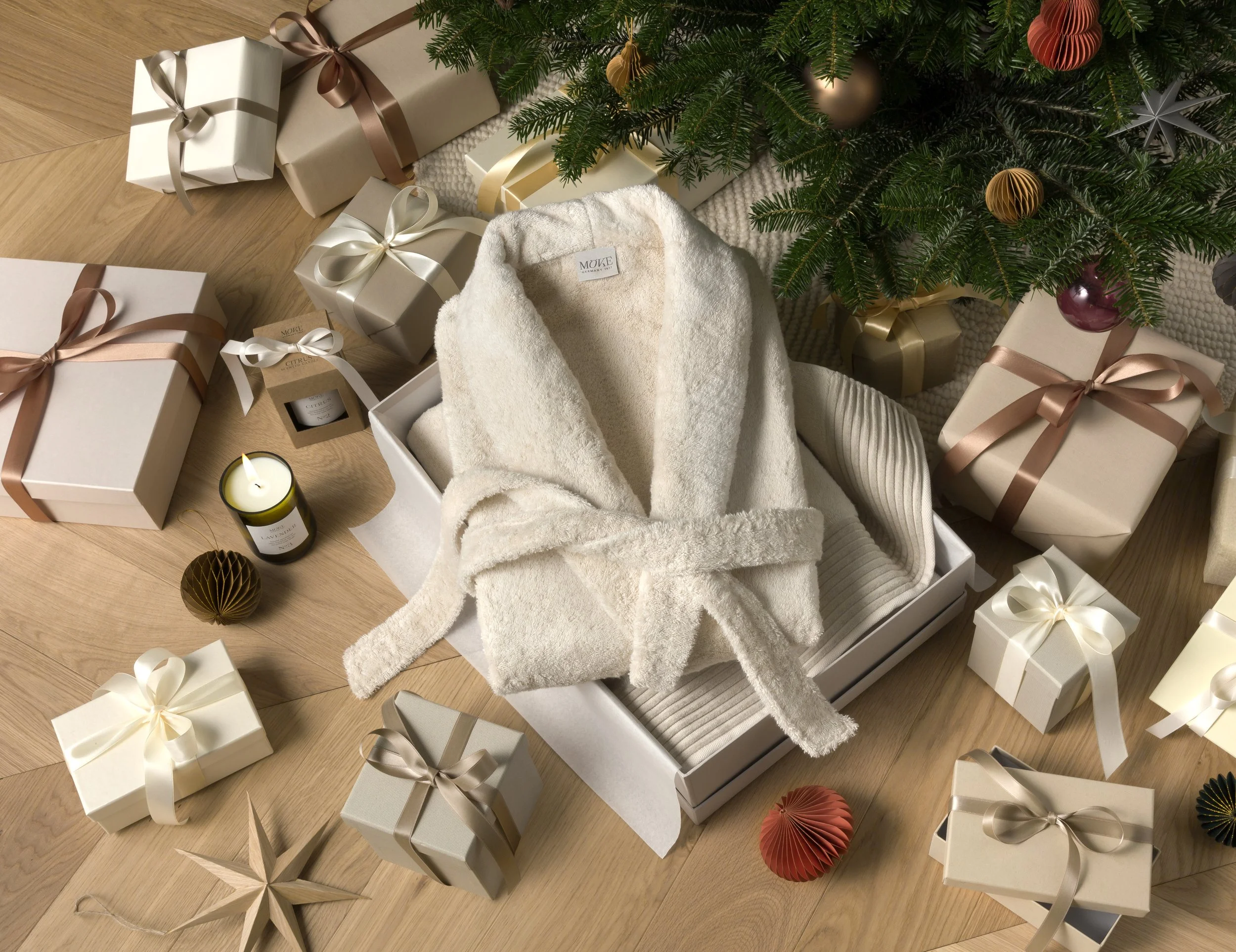Christmas campaign still life featuring Möve bathrobe presented in gift box surrounded by wrapped presents and festive decorations, set construction and props styling by Steffi Bühlmaier, photography by Michael Tewes, creative direction by Studio Küh