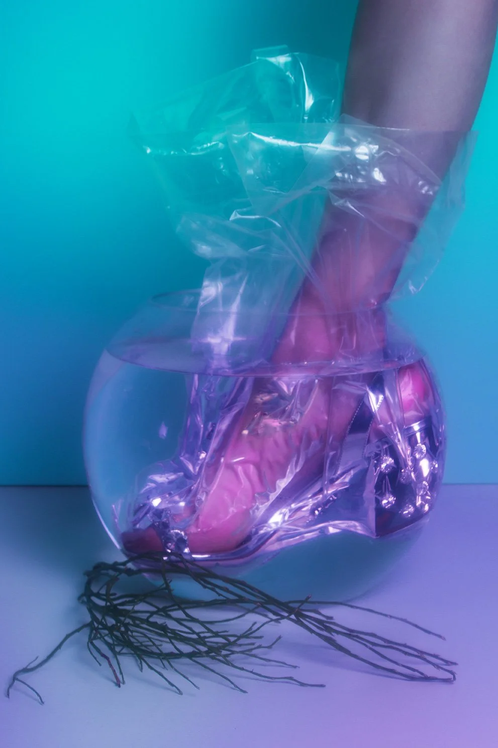 Editorial fashion image featuring legs in transparent footwear staged within golfish bowl, set design and props styling by Steffi Bühlmaier, photography by Loreen Hinz for Vision Magazine China, 2019