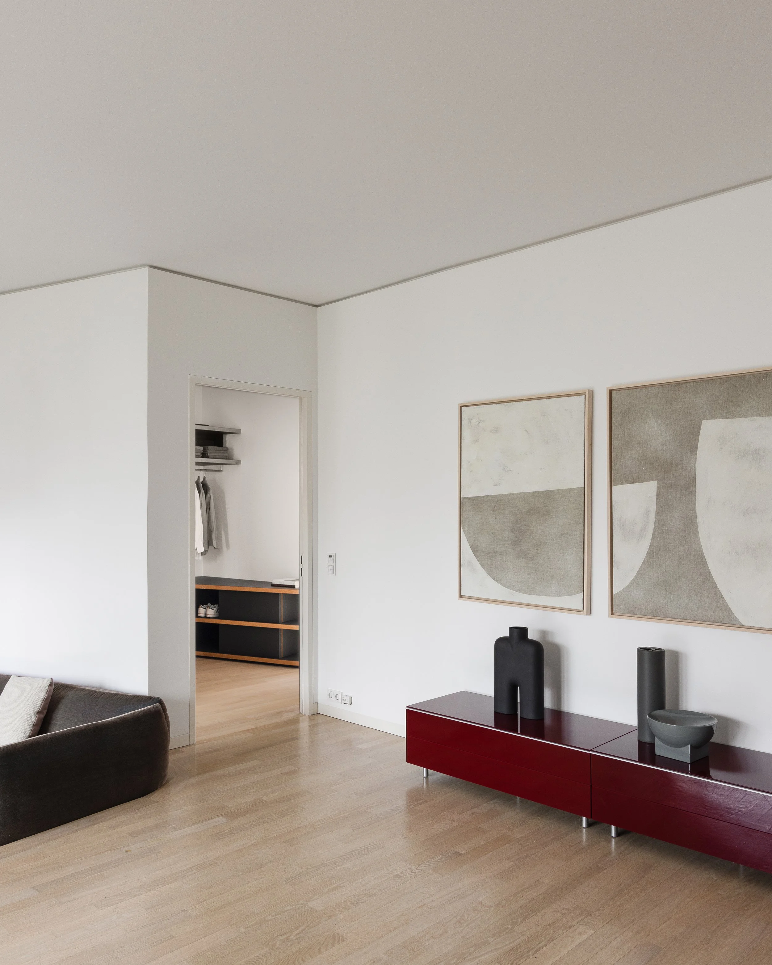 Modern living room detail with red sideboard and abstract artwork, apartment in Berlin Mitte, home staging and interior styling by Steffi Bühlmaier, photography by Jordana Schramm, 2025