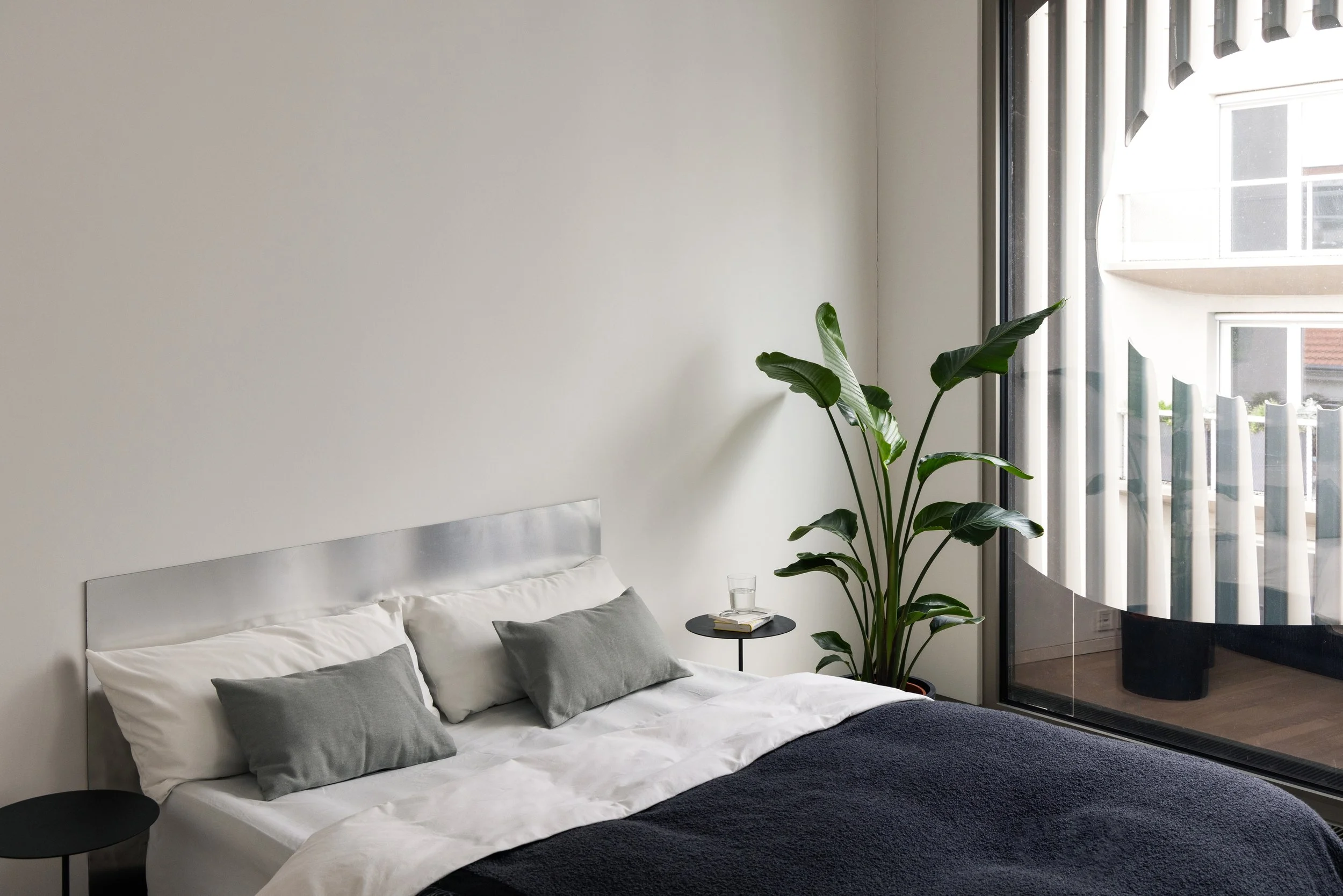 Bright bedroom interior with large windows and balcony access, apartment in Berlin Mitte, home staging and interior styling by Steffi Bühlmaier, photography by Jordana Schramm, 2025