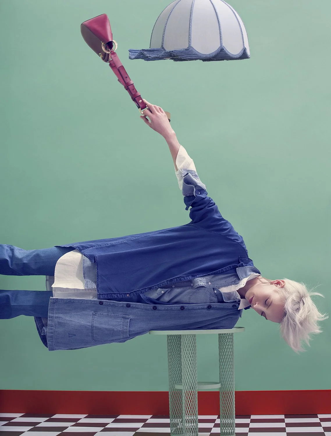 Fashion editorial with model balancing under pendant lamp against green backdrop, art direction and styling by Steffi Bühlmaier, editorial in jolie magazine