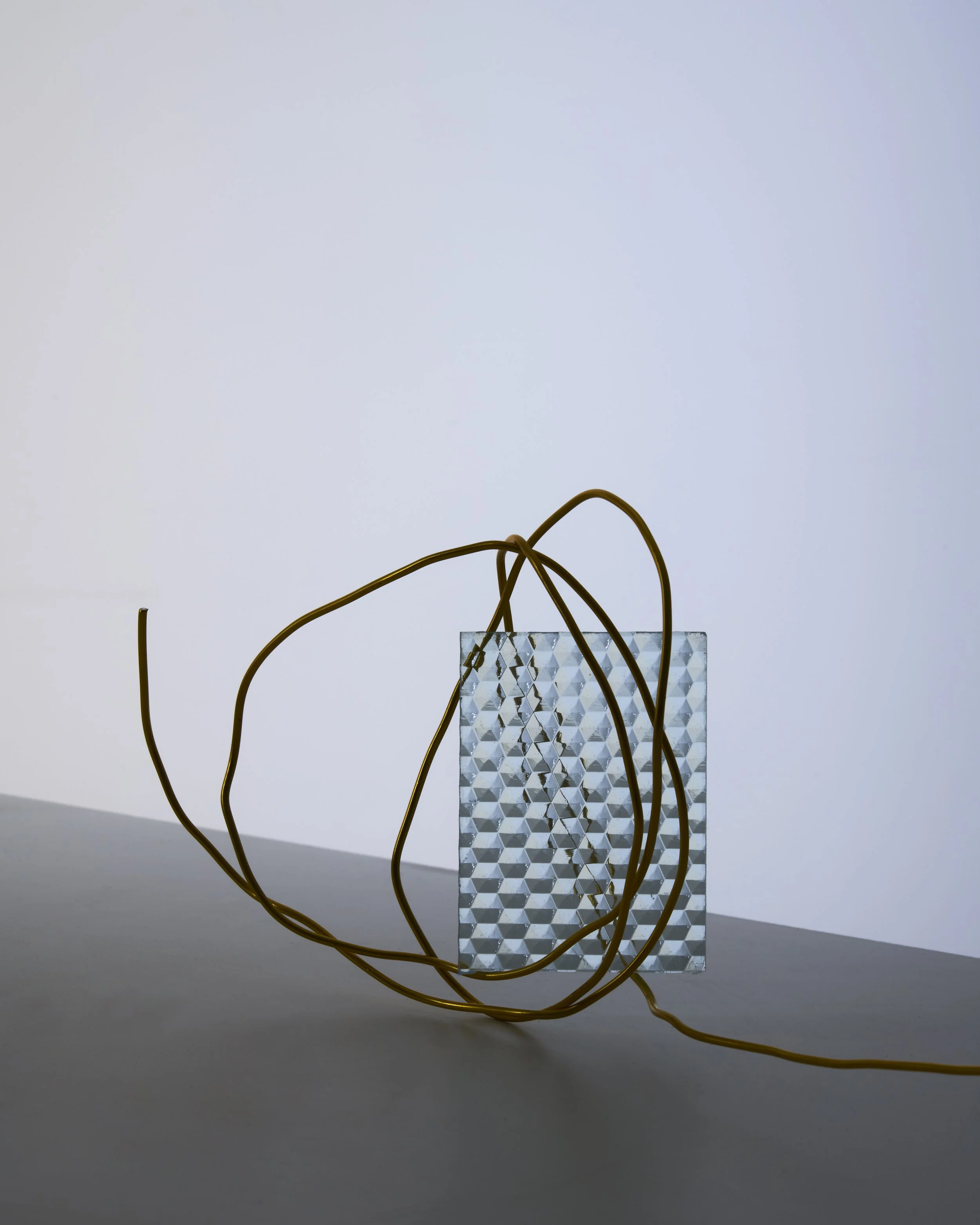 Still life composition with textured glass block and wrapped golden wire, set design and props styling by Steffi Bühlmaier, photography by Paul Kusserow, 2020