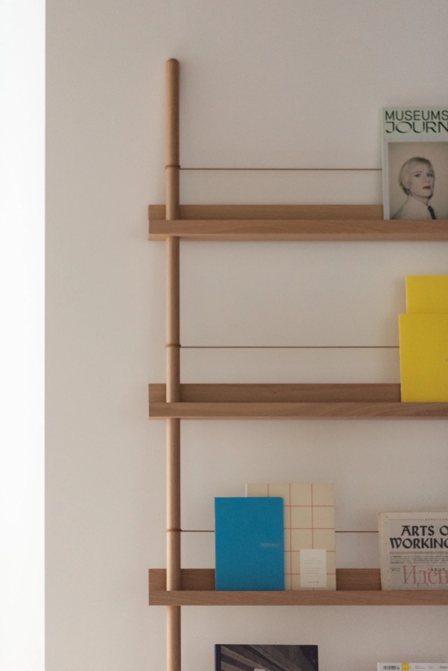 Minimal wooden wall shelving with curated books and magazines, office interior in Berlin Charlottenburg, interior styling by Steffi Bühlmaier, architecture by BBPA, 2024