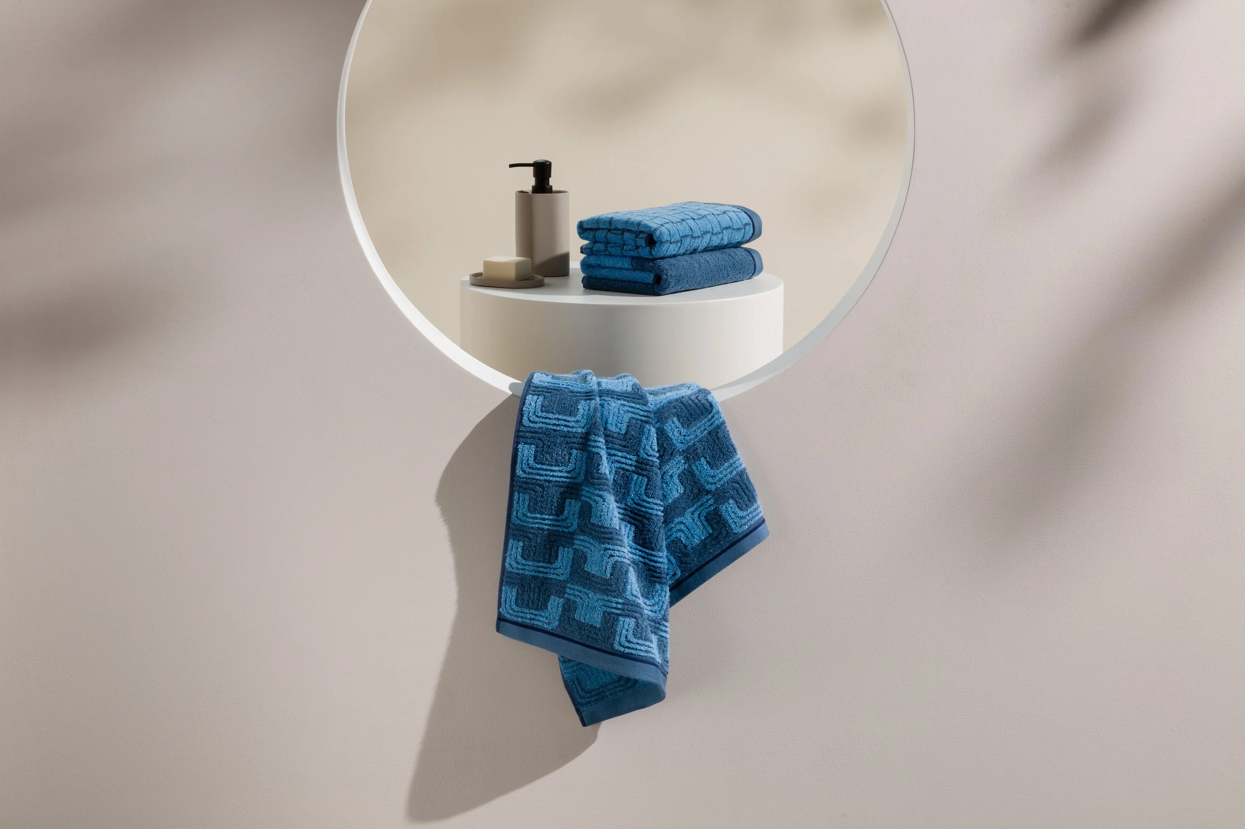 Still life featuring draped towel and bathroom products staged in circular display niche, set build and props styling by Steffi Bühlmaier, photography by Michael Tewes, creative direction by Studio Kühn for Möve, 2025