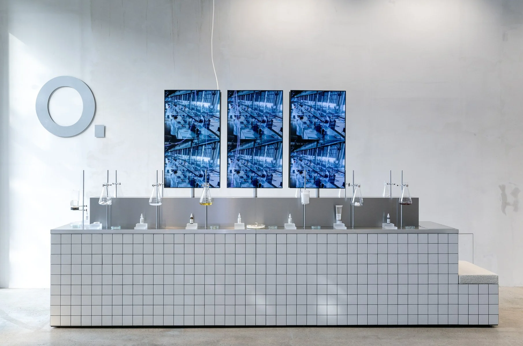 Retail interior with tiled sink installation and mirrored logo on the wall, spatial design and styling by Steffi Bühlmaier for The Ordinary.