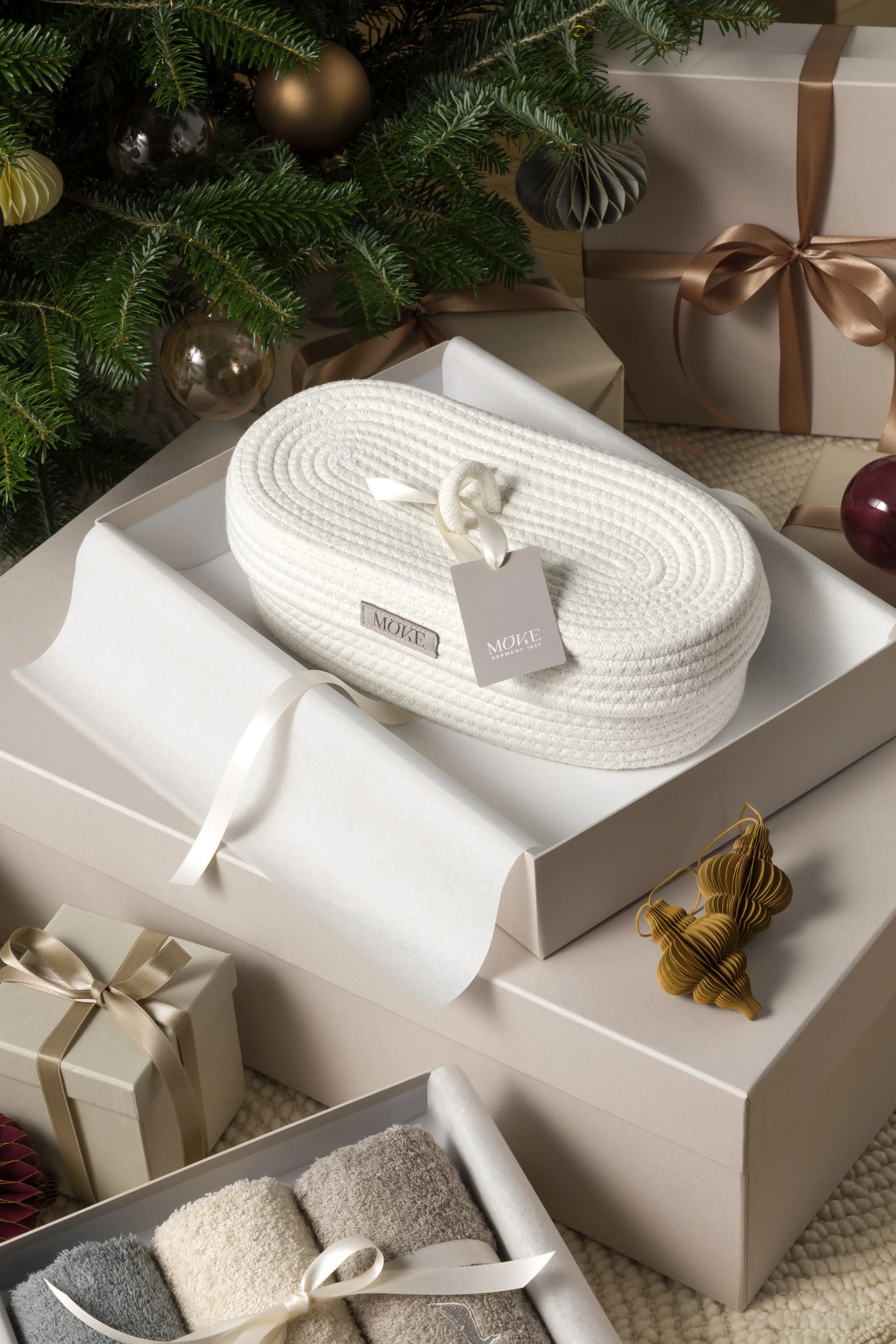 Still life of the Möve Christmas campaign featuring woven wellness accessories presented in layered gift boxes with festive ornaments, set construction and props styling by Steffi Bühlmaier, photography by Michael Tewes, creative direction by Studio 