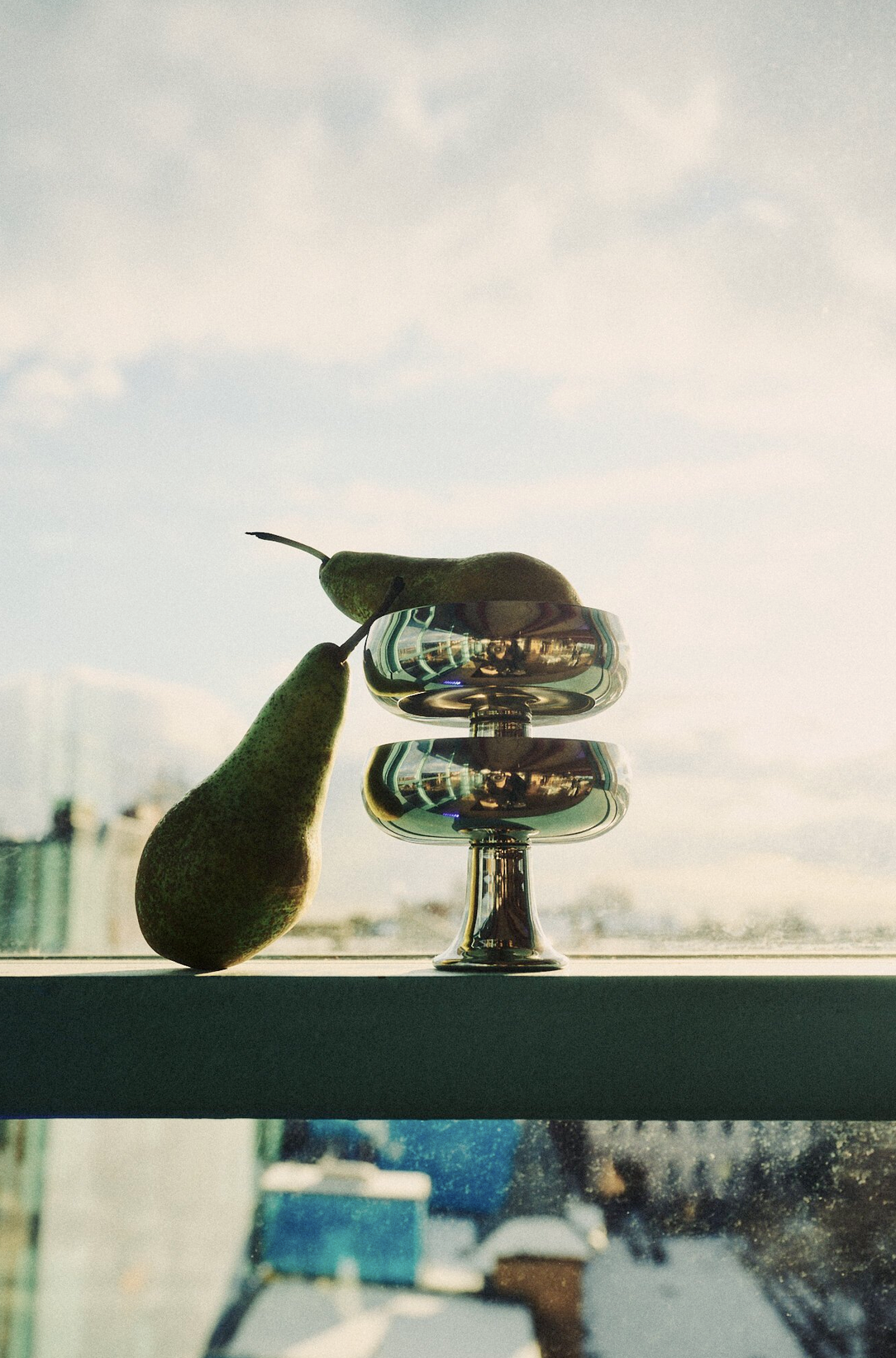 Pear arrangement on reflective pedestal by rooftop window, event design and props styling by Steffi Bühlmaier for Lidl x Highsnobiety dinner at Ember Rooftop Berlin, production by PS:KAAS, 2025