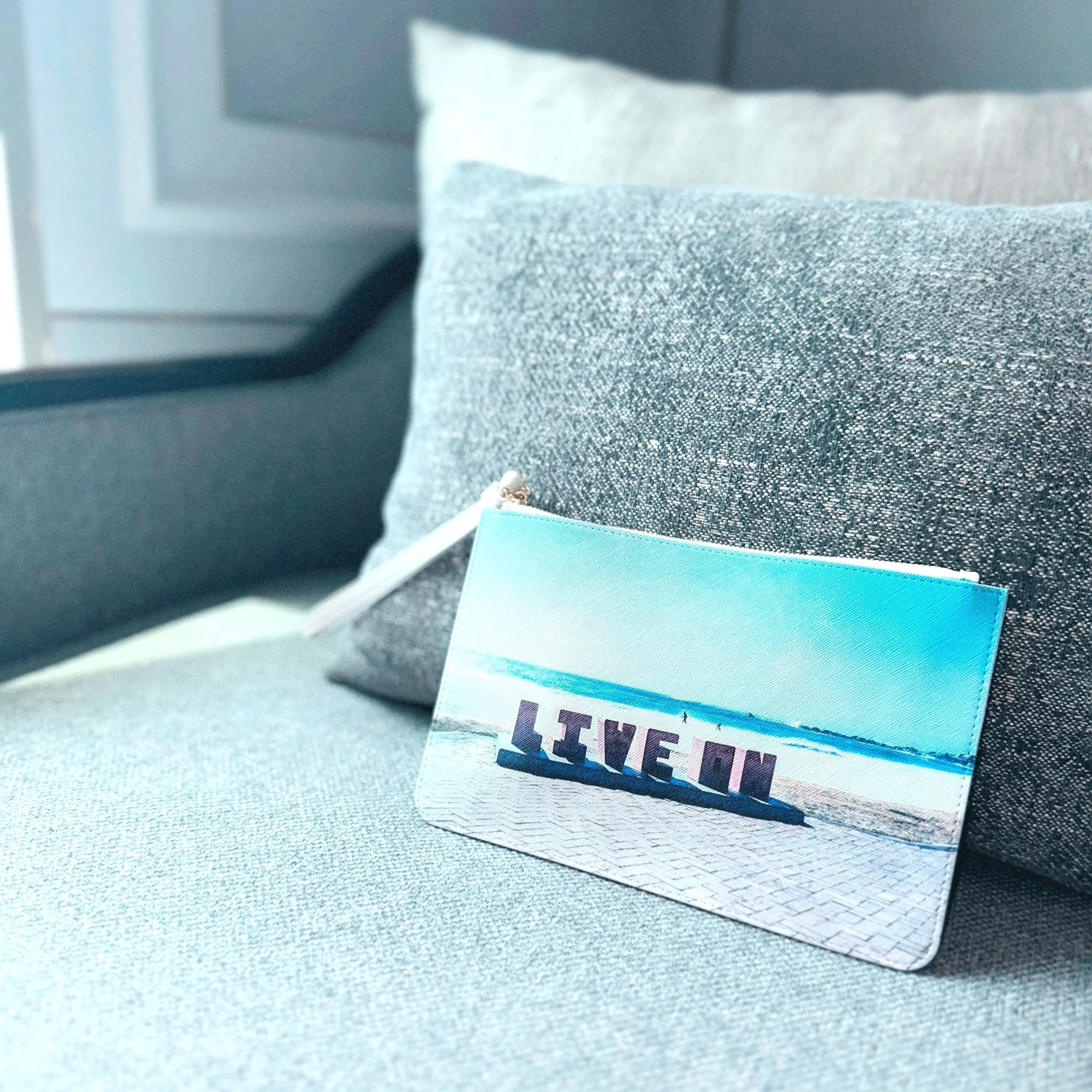 Minimalistische Clutch mit Strandfotografie & Aufschrift „LIVE IN“ – Designprodukt aus dem limiloulu Concept Store