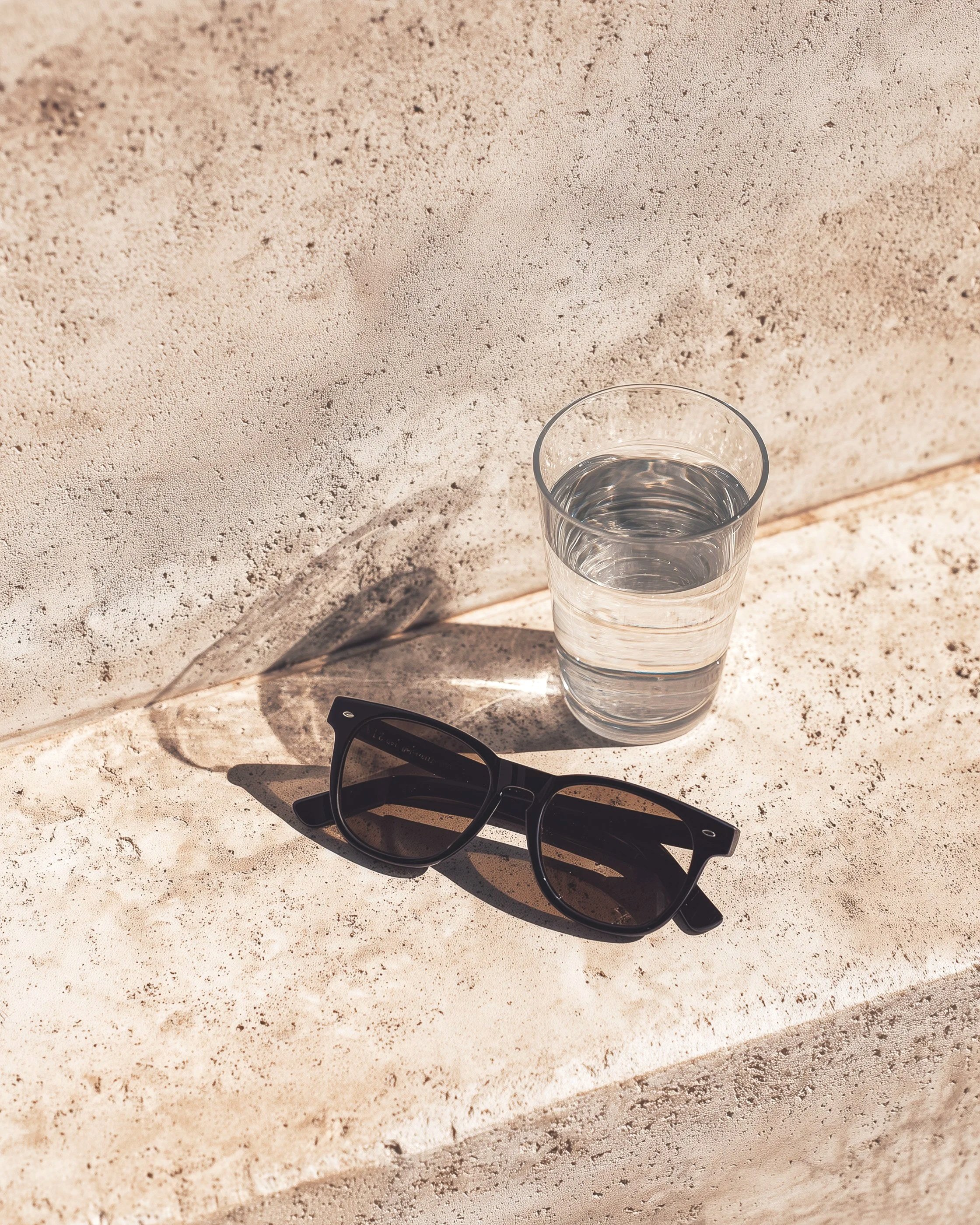 B-Roll Hintergrund Bild mit Wasserglas und Sonnenbrille auf Treppenstufe - beige