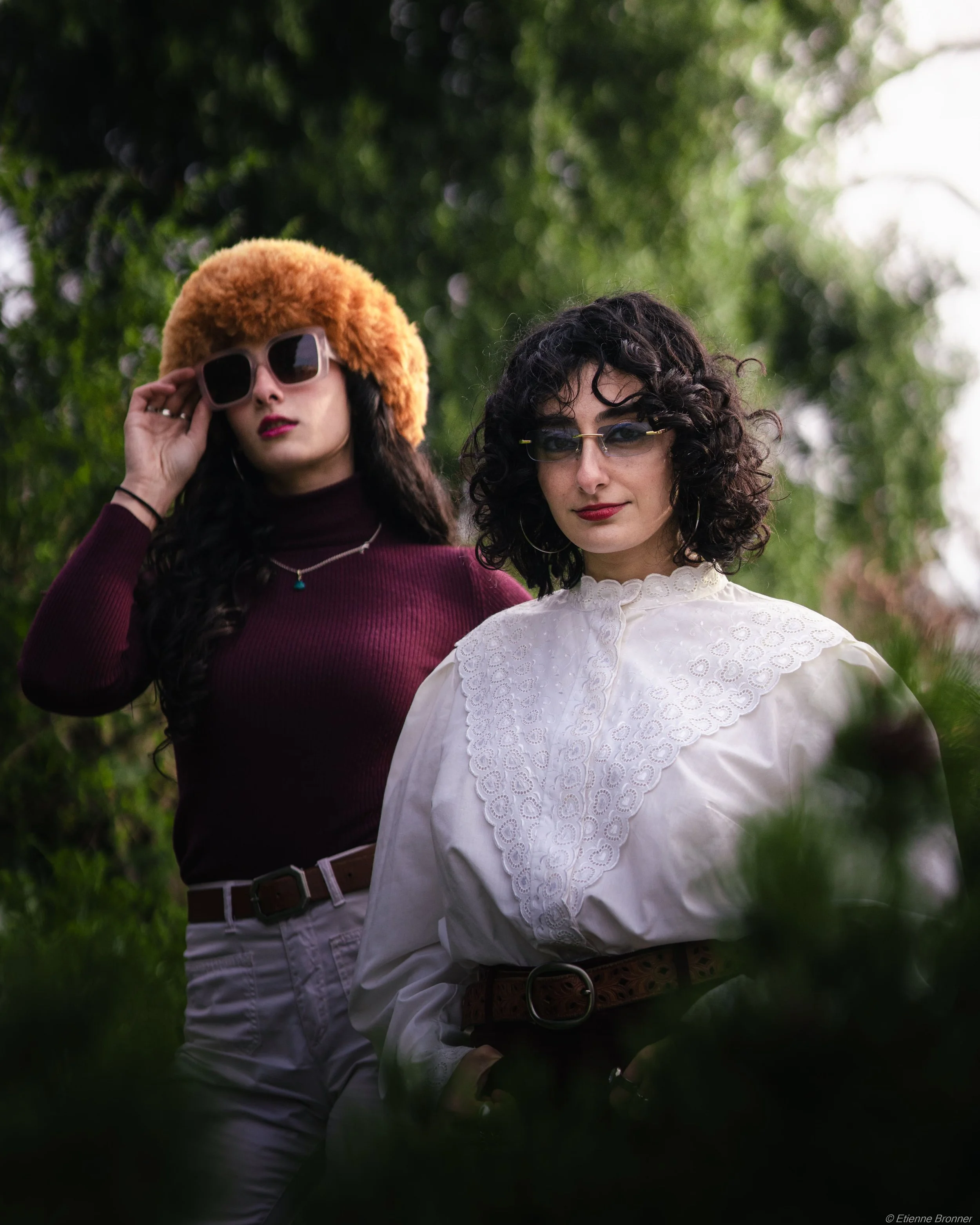 Portrait de deux femmes avec des coiffures bouclées portent des vêtements vintage au parc Monceau.