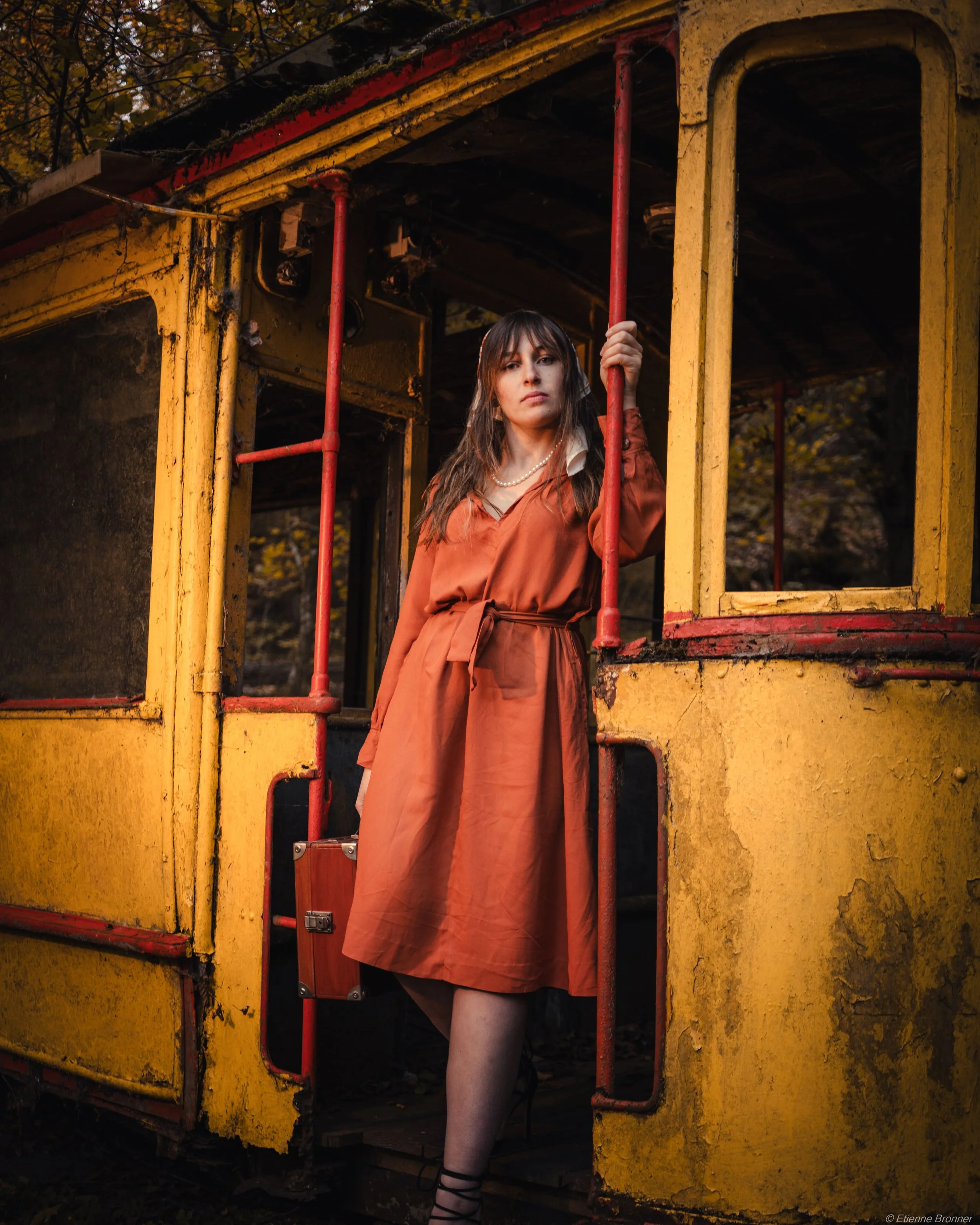 Portrait d'une femme en robe vintage sortant du tram jaune abandonné