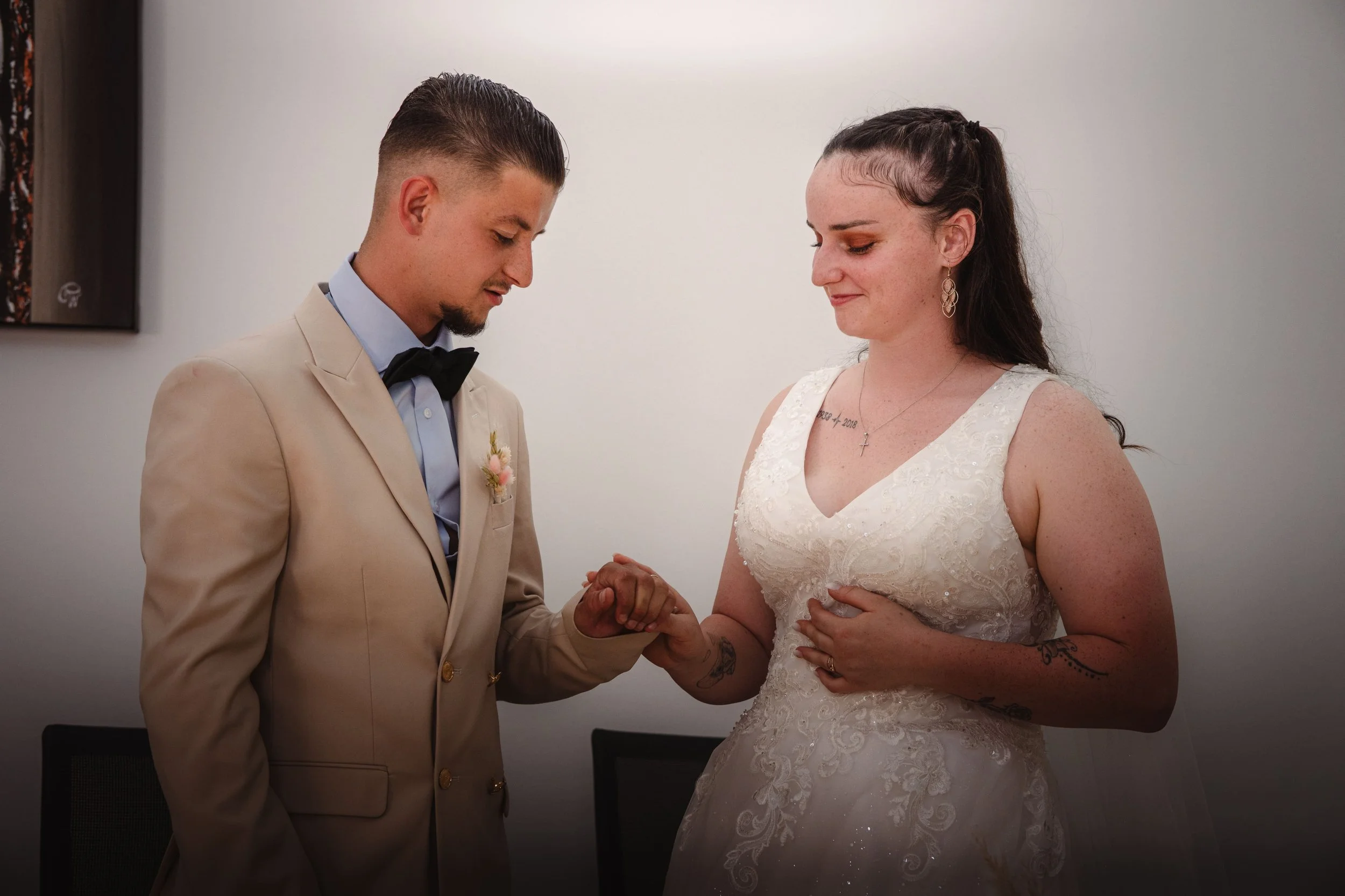 Portrait d'un couple en costume de mariage échangeant des vœux lors de leur cérémonie nuptiale, se tenant la main, dans une mairie en Alsace.
