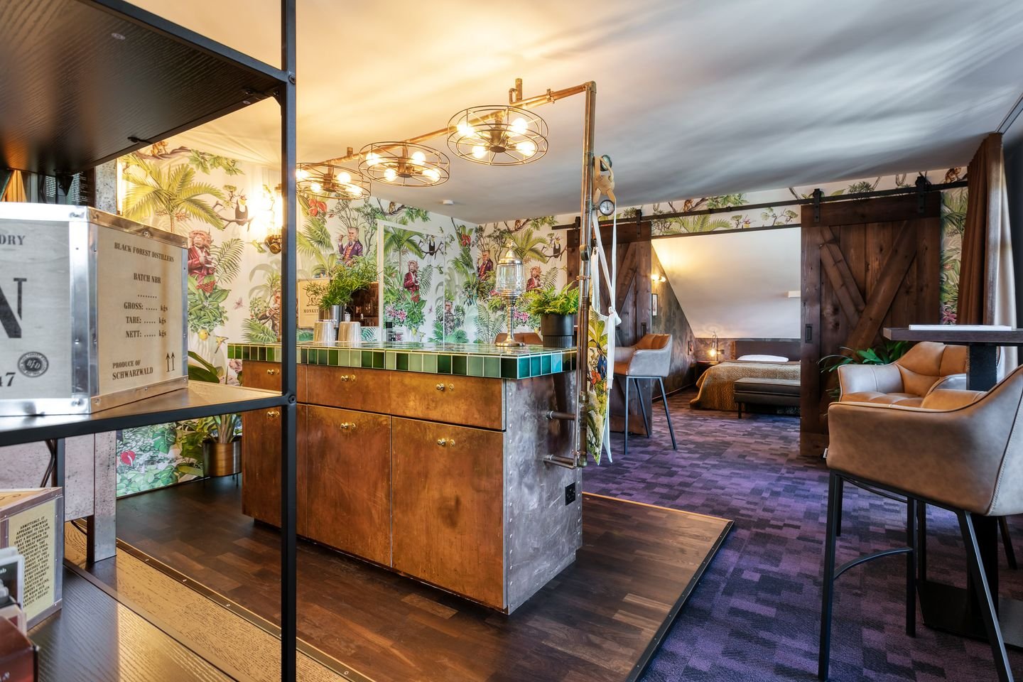 Gemütliche Bar mit tropischer Wanddekoration und komfortablen Sitzgelegenheiten im Hintergrund.