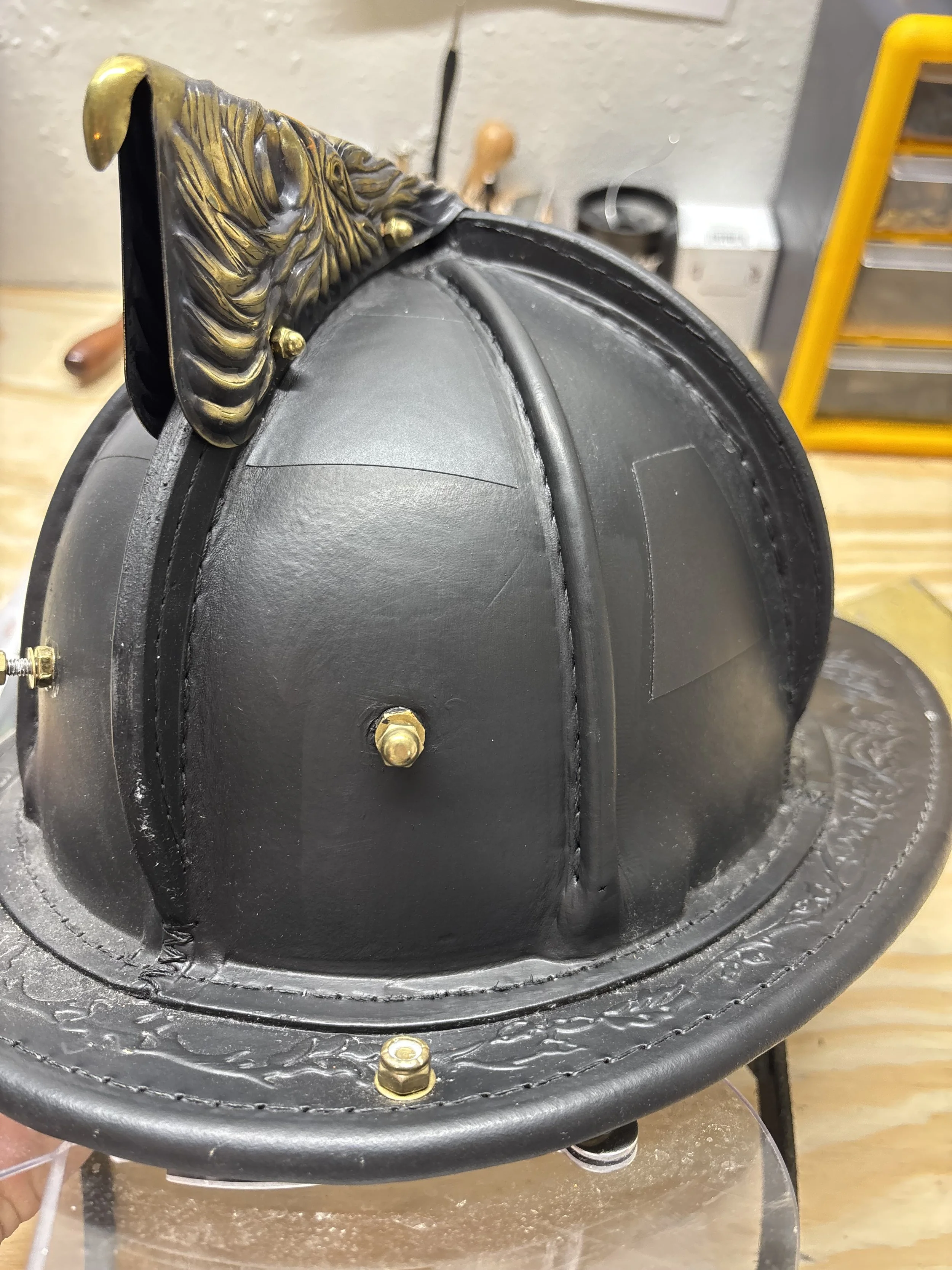Close-up view of a decorative, black and gold costume hat or headpiece with ornate details and a wide brim.