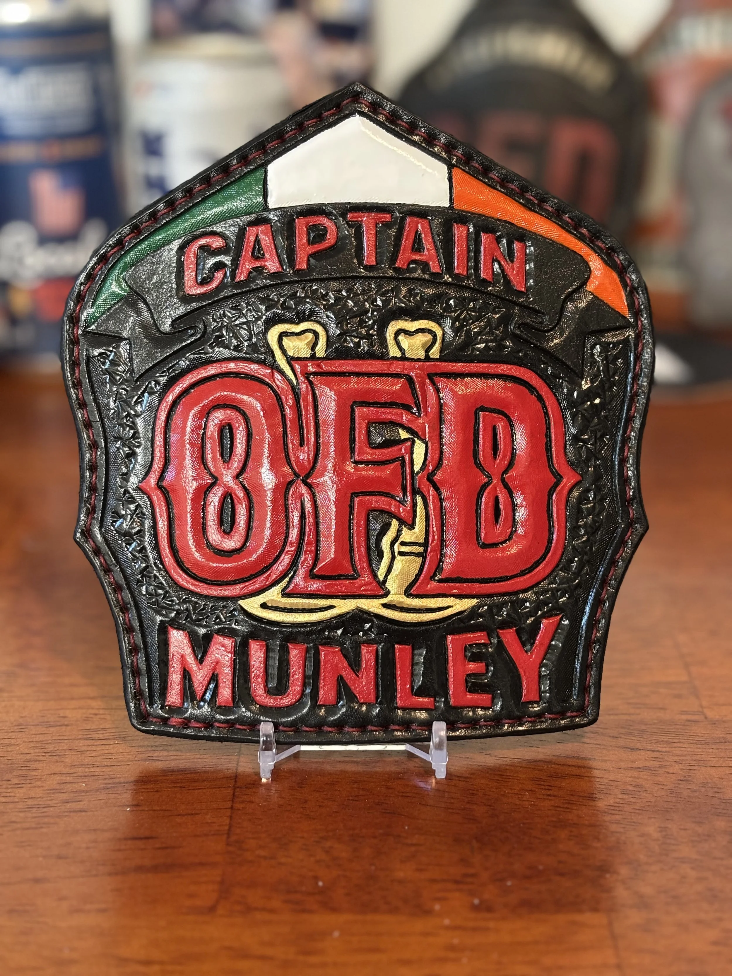 Leather firefighter patch reading "Captain Munley" with a fire helmet graphic and Irish flag colors.