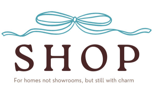 Logo featuring a blue bow with the word 'SHOP' underneath and the tagline 'For homes not showrooms, but still with charm'.