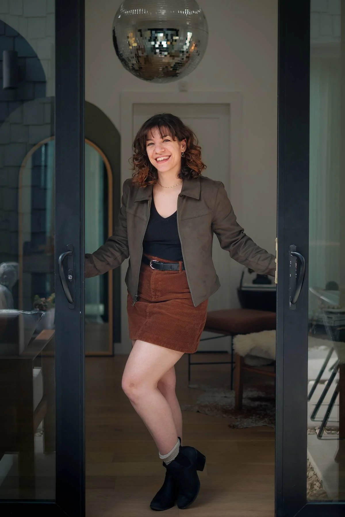 Copywriter Rebecca Brumberg standing in a doorway and grinning.
