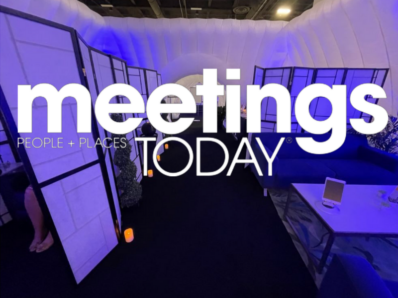 Indoor event space with purple lighting, a seating area with a table, and a decorative partition. Prominently displays the text 'Meetings TODAY.'