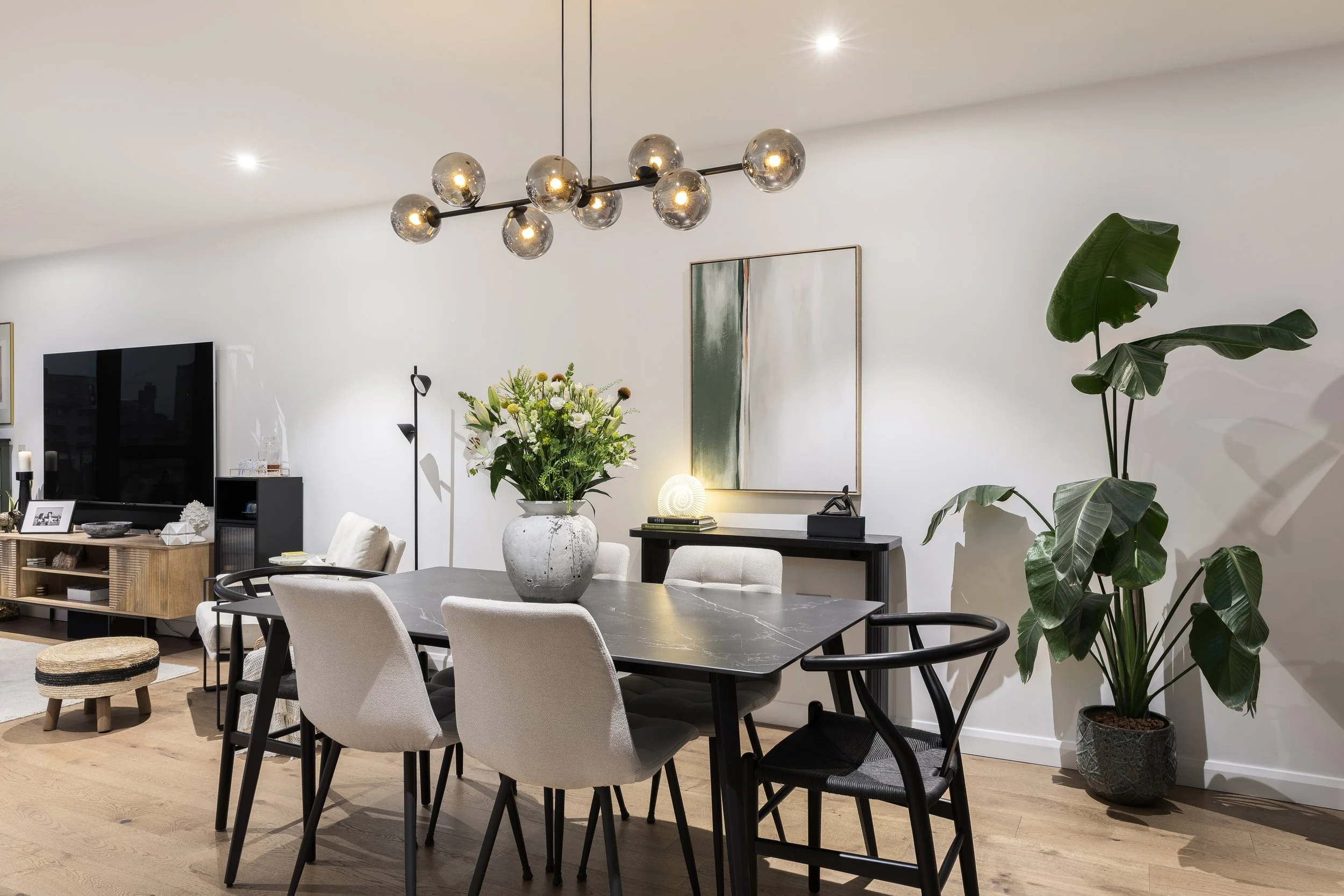 Dining area with sculptural pendant light and velvet chairs, Limehouse Cut East London by Rodolfo Falcao