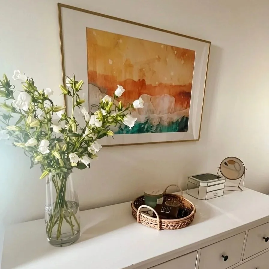 Styled white dresser with floral arrangement and abstract artwork, Battersea London interior design by Rodolfo Falcao