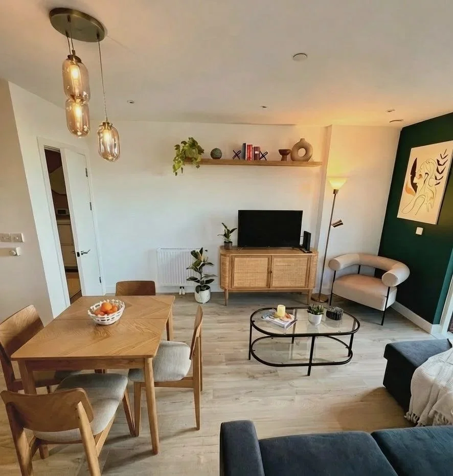 Open plan living and dining space with forest green feature wall, Battersea London flat by Rodolfo Falcao