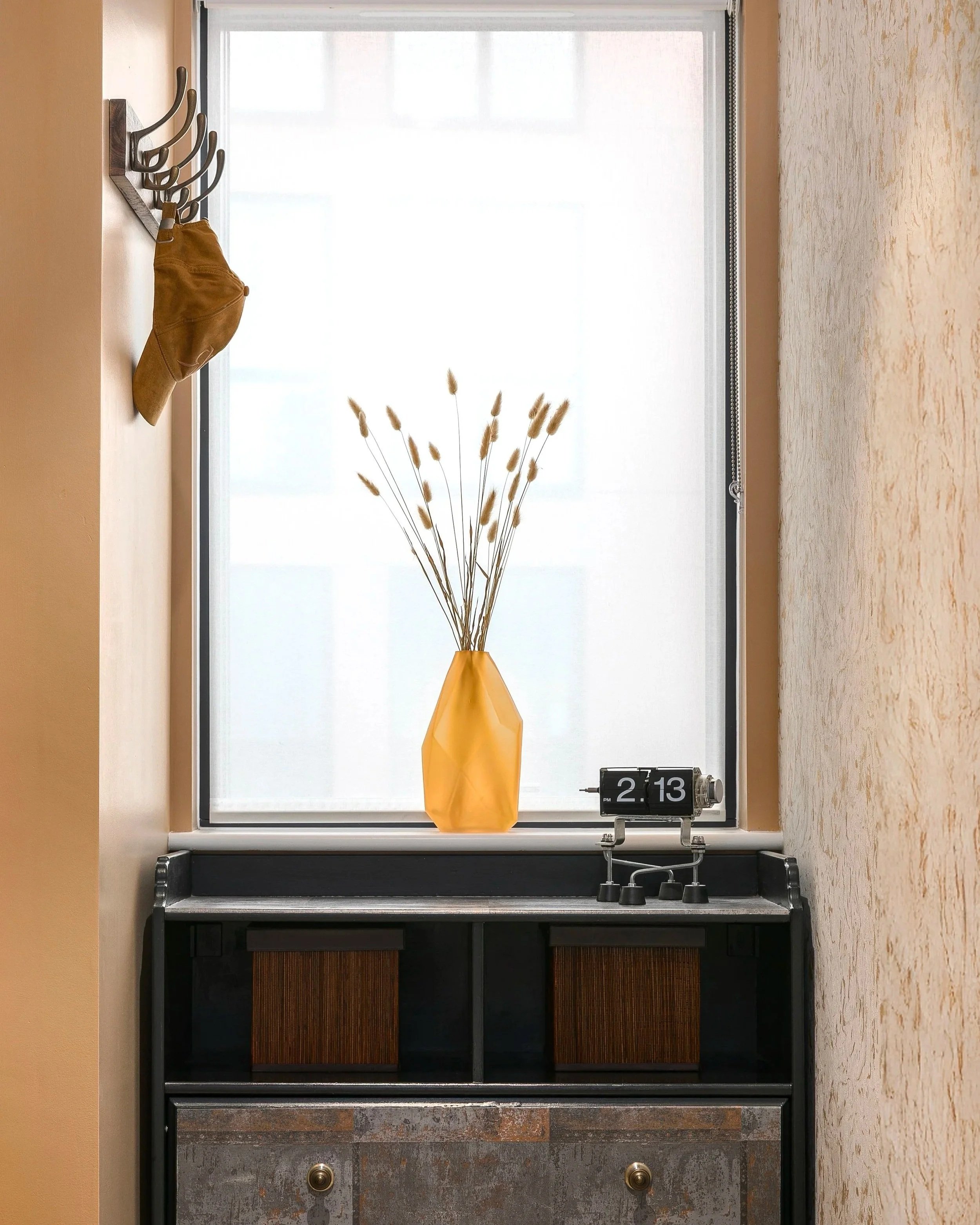 Vintage black sideboard with ceramic vase and dried stems, eclectic interior styling by Rodolfo Falcao, Bow East London