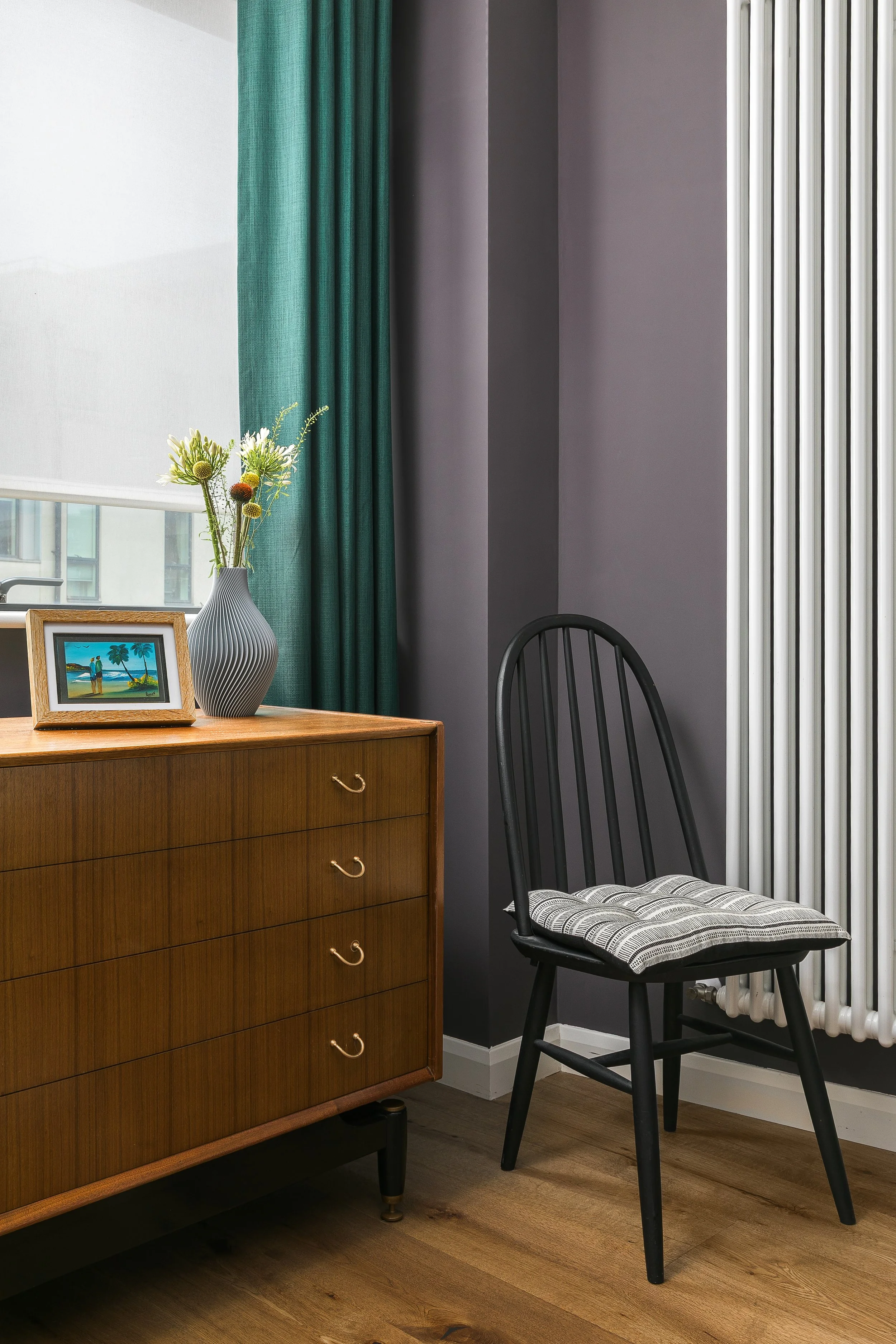 Vintage teak chest of drawers with brass pulls and black Windsor chair, Bow East London apartment by Rodolfo Falcao