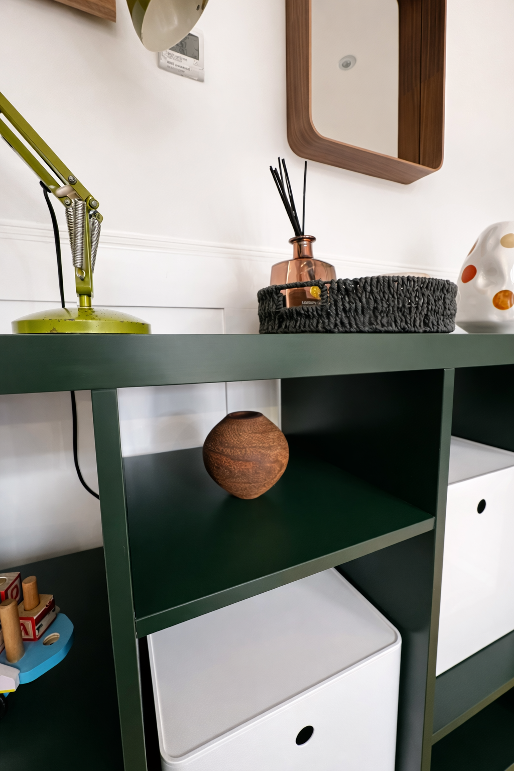 Forest green shelving unit with styled accessories, Oxford family home interior design by Rodolfo Falcao