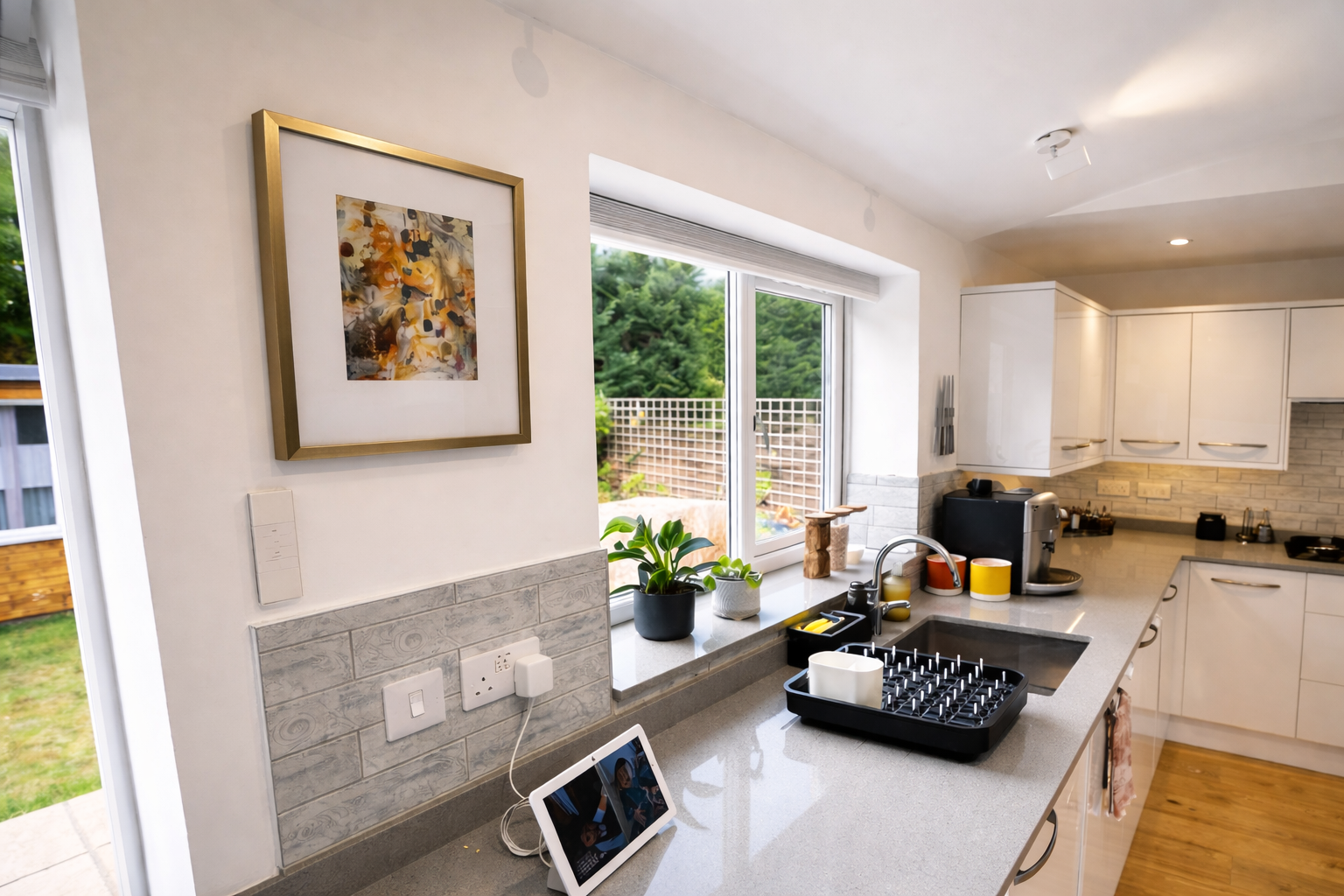 Kitchen worktop with abstract artwork and garden window, Oxford family home by Rodolfo Falcao