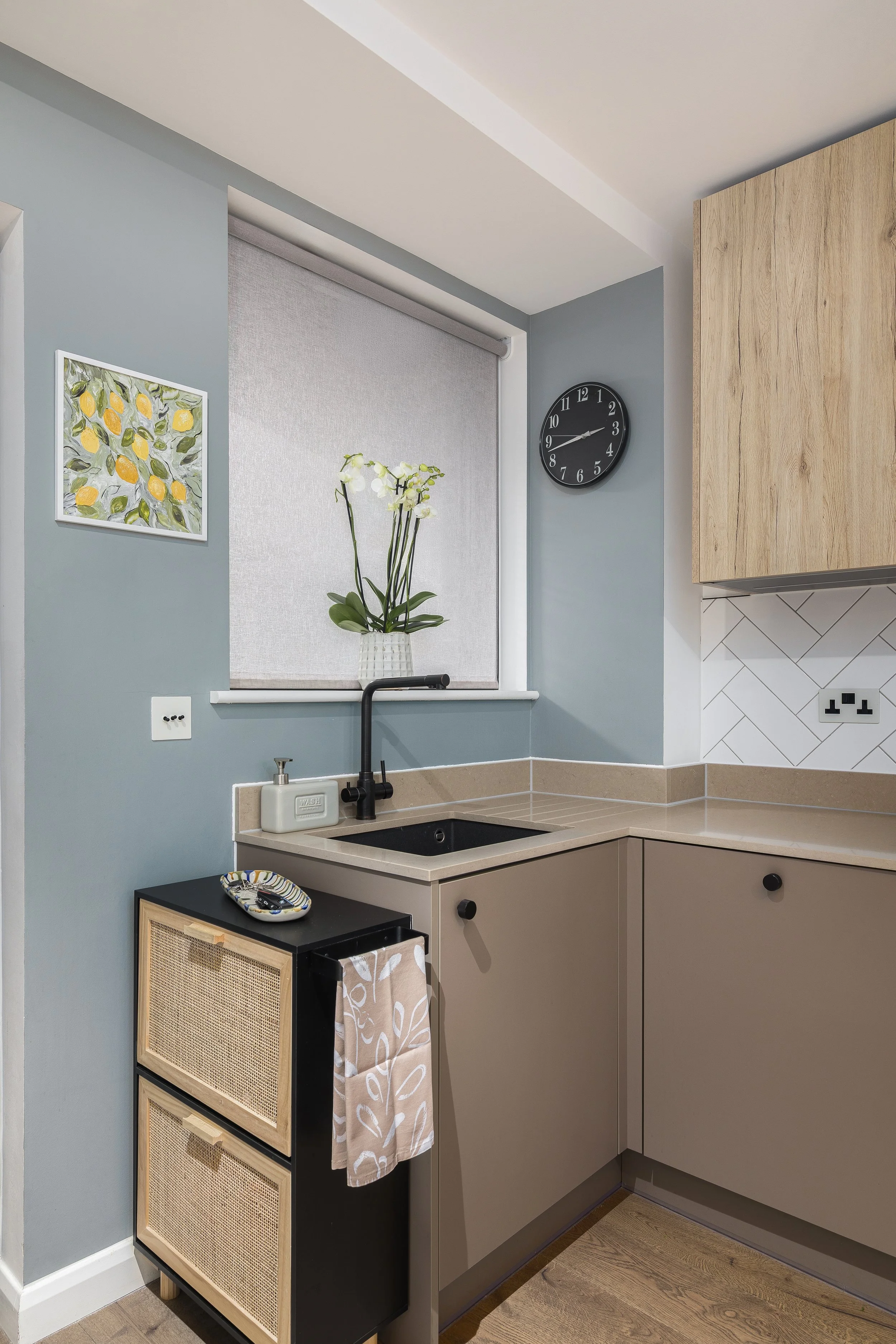 Kitchen sink area with duck egg blue walls and rattan shoe rack, Limehouse Cut London apartment by Rodolfo Falcao