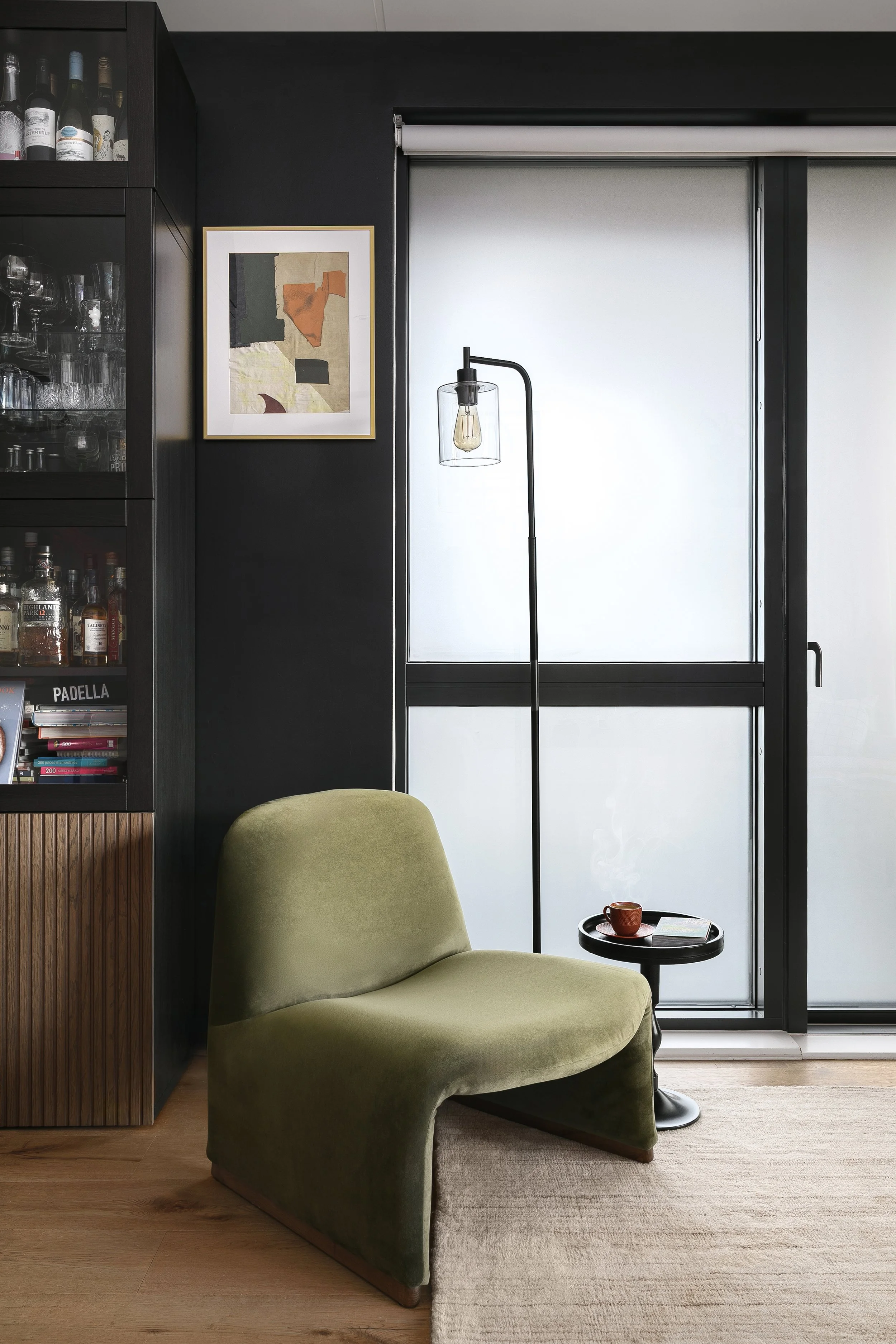 Living space with olive green lounge chair and black walls, Bow East London interior design by Rodolfo Falcao