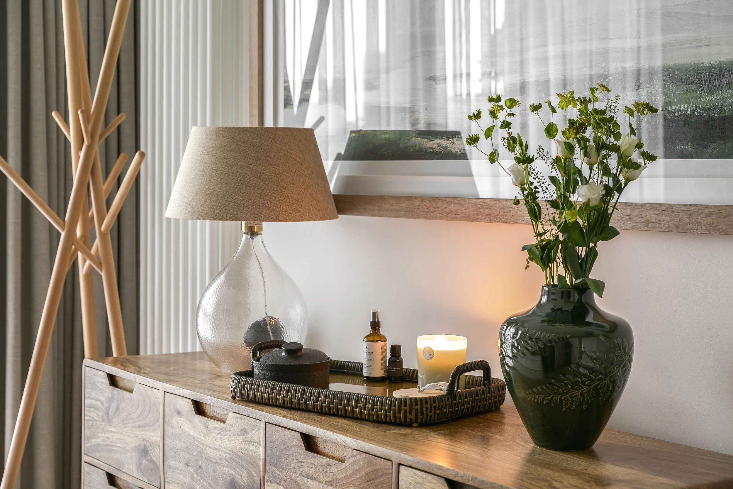 Styled side table with rattan lamp and dark ceramic vase, Limehouse Cut East London apartment by Rodolfo Falcao