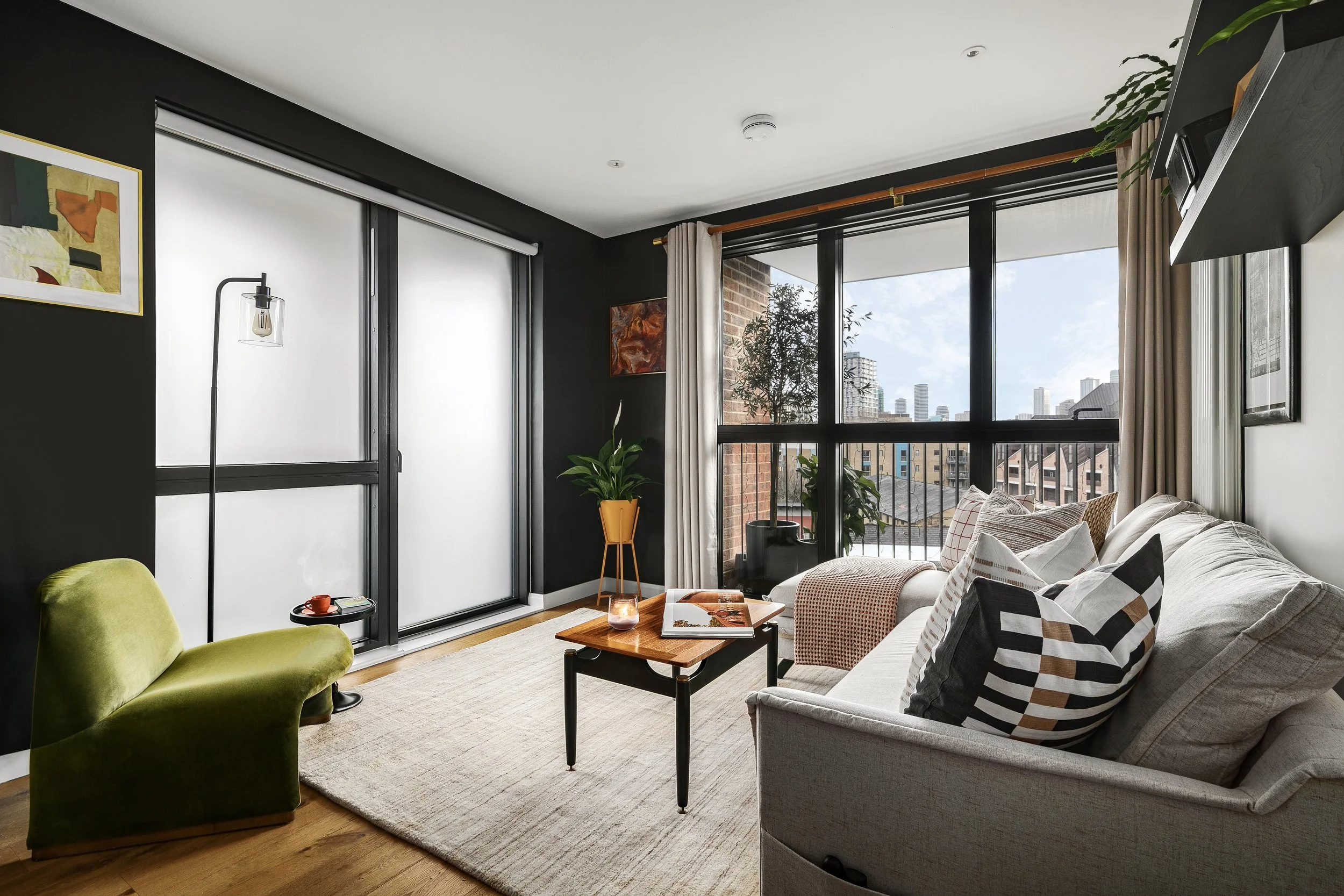 Open plan living room with city views and eclectic furniture, Bow East London apartment by Rodolfo Falcao